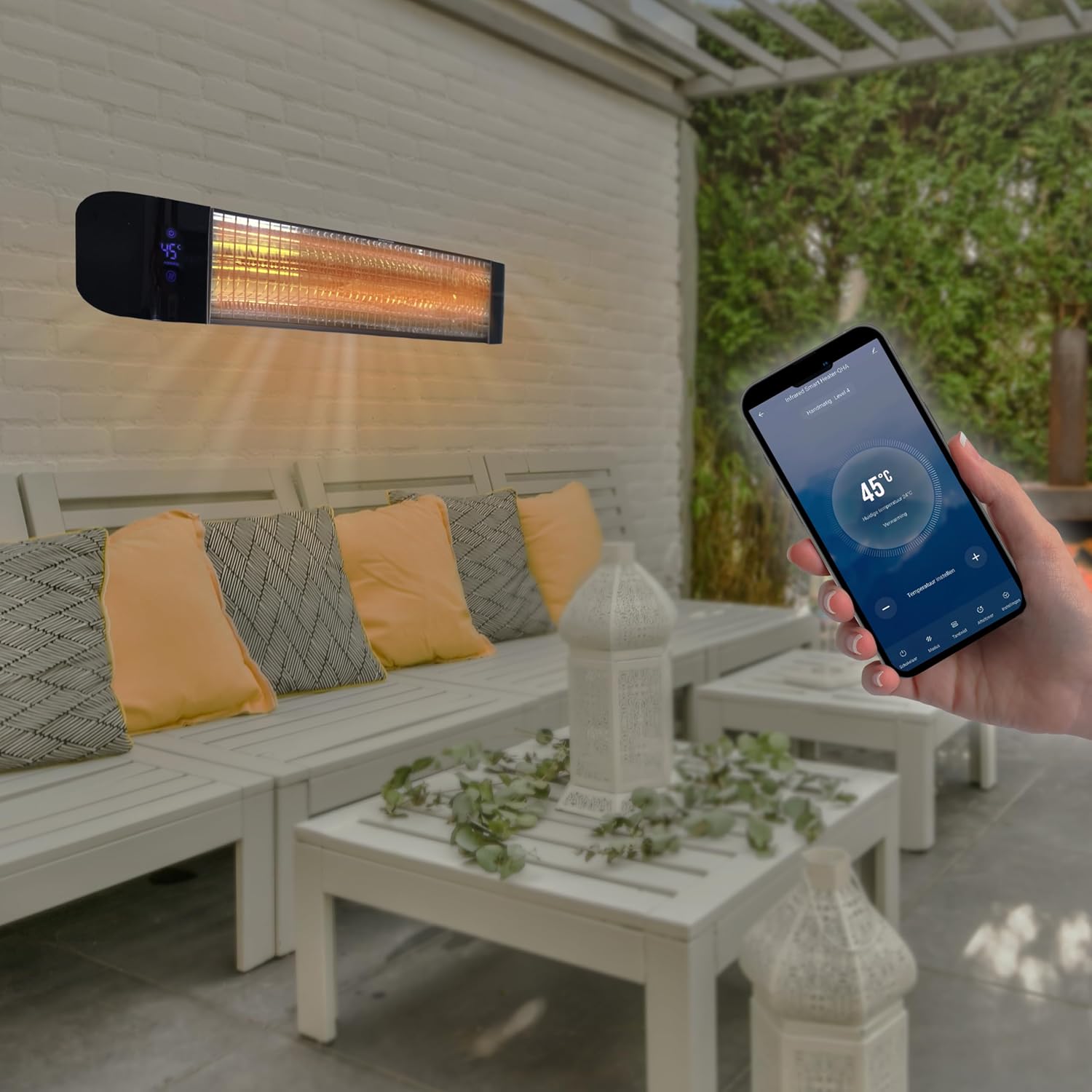 Silvergear patio heater mounted on a wall with a hand holding a smartphone showing the control app