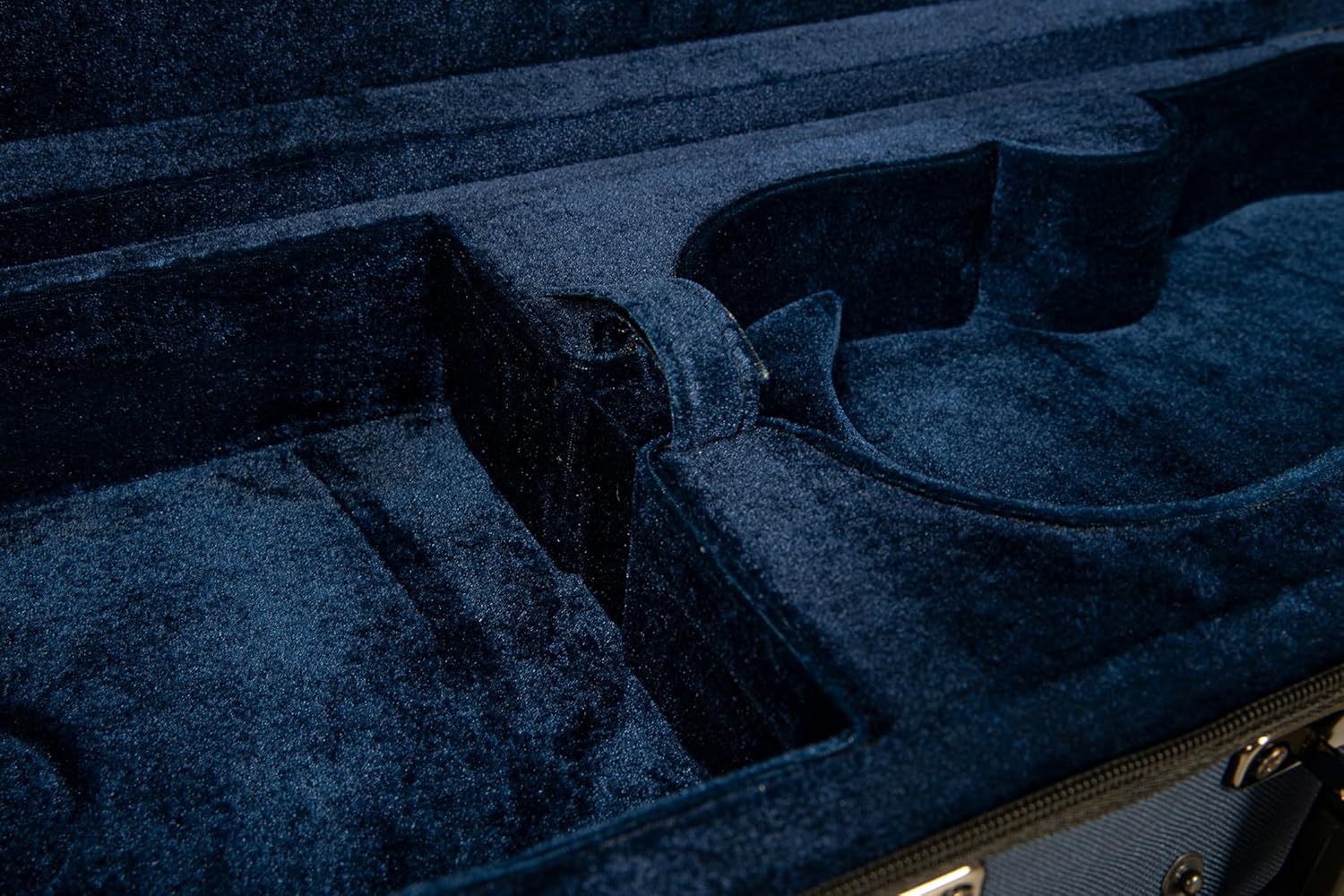 Close-up of the dark blue velvet interior of the Gewa Violin Case PS350110, showing a bow holder and accessory space.