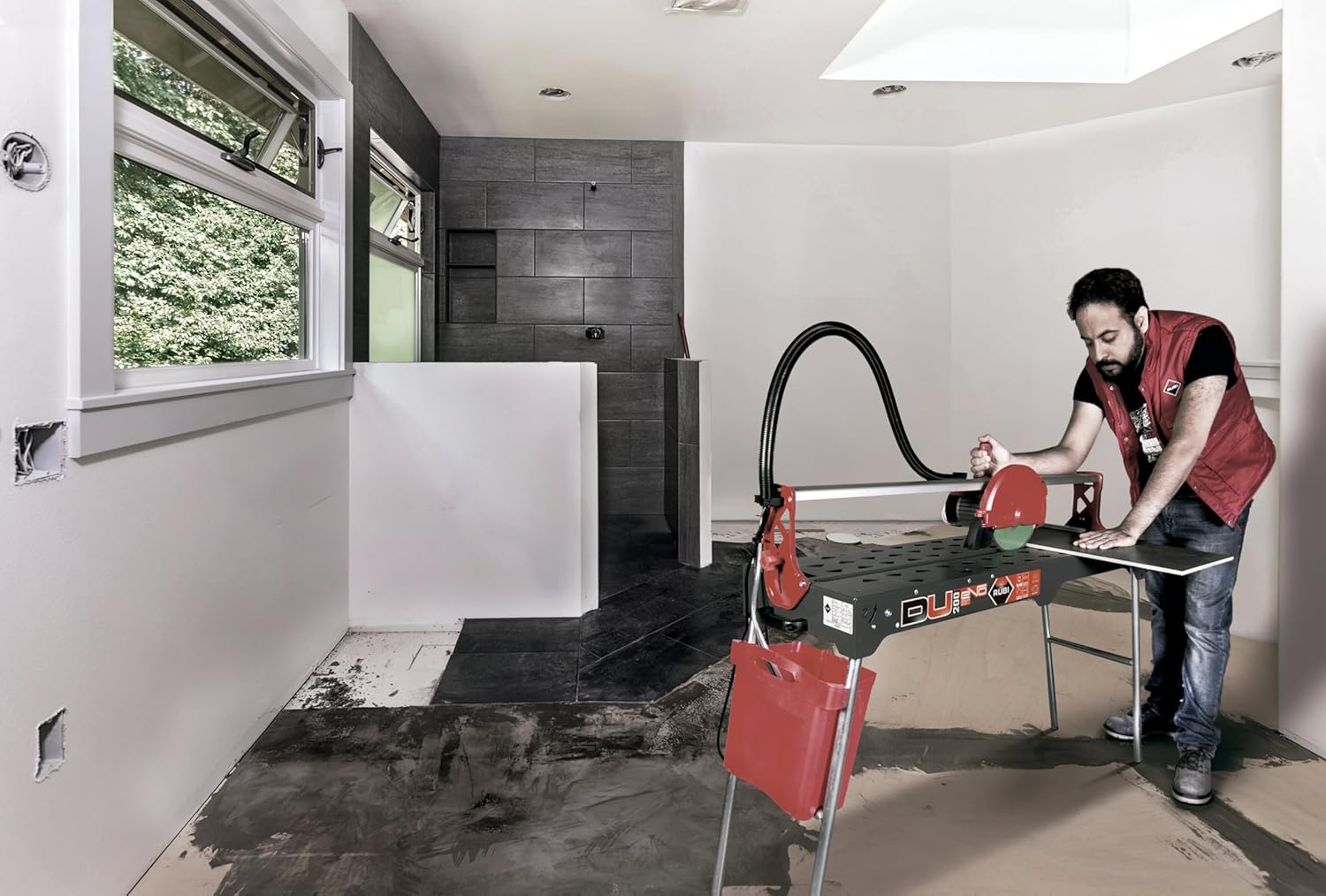 A person operating the Rubi Tools DU-200 EVO 850 Tile Saw in a room with tiled walls.