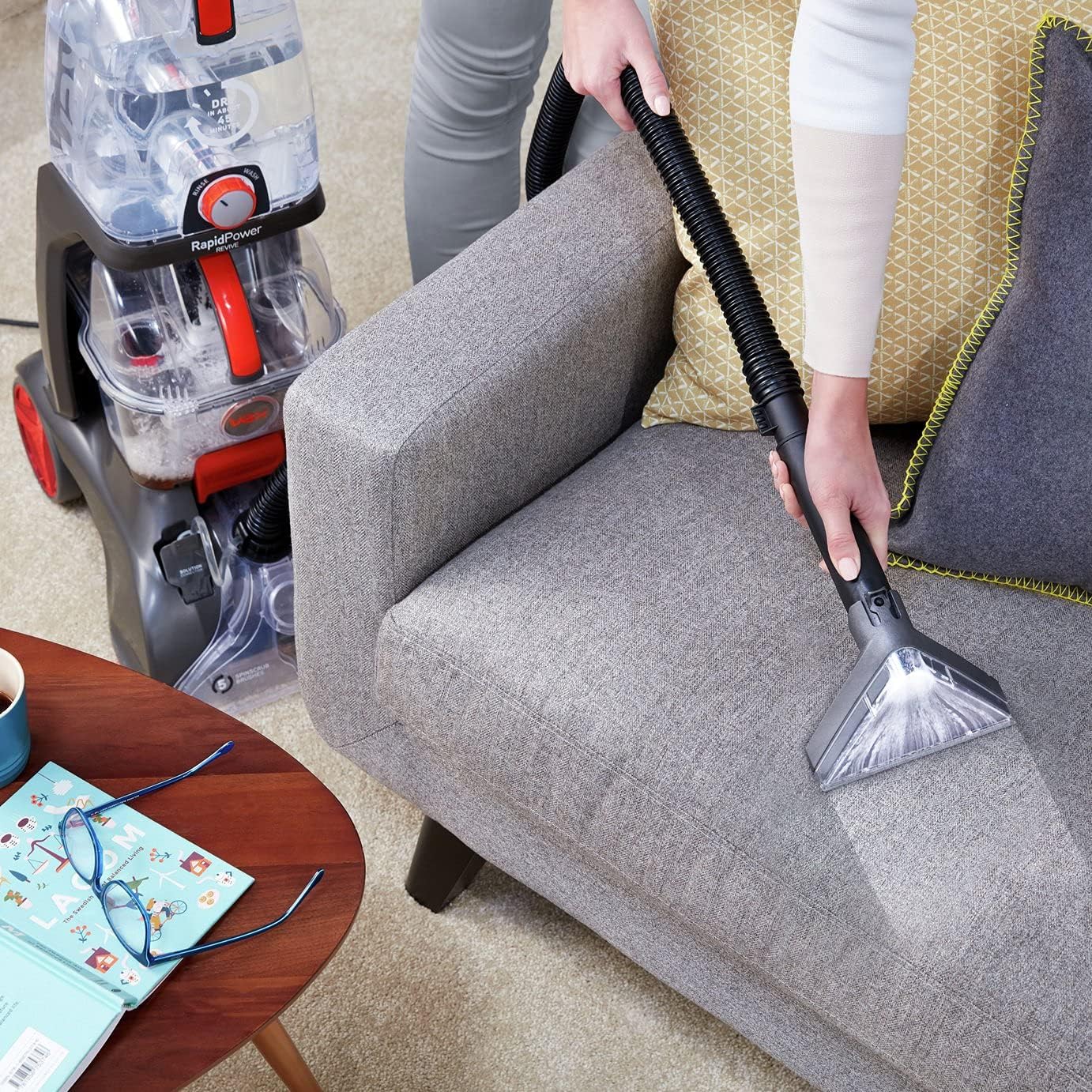 Woman using upholstery tool on a sofa