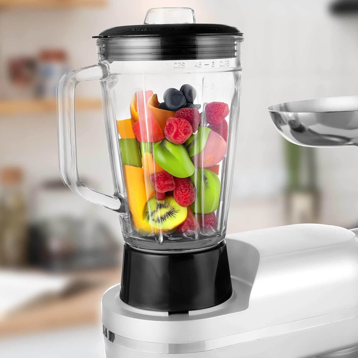 Blender jug filled with various fruits and berries, ready for blending