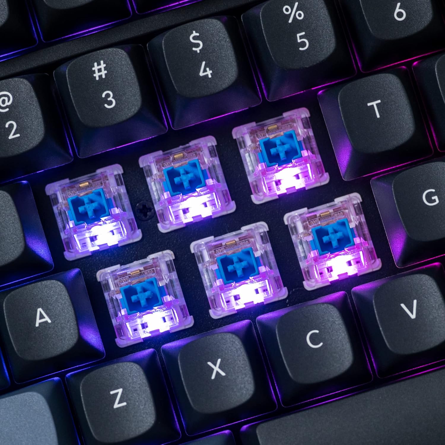 Close-up of hot-swappable mechanical switches on the Keychron V5 keyboard with RGB lighting.