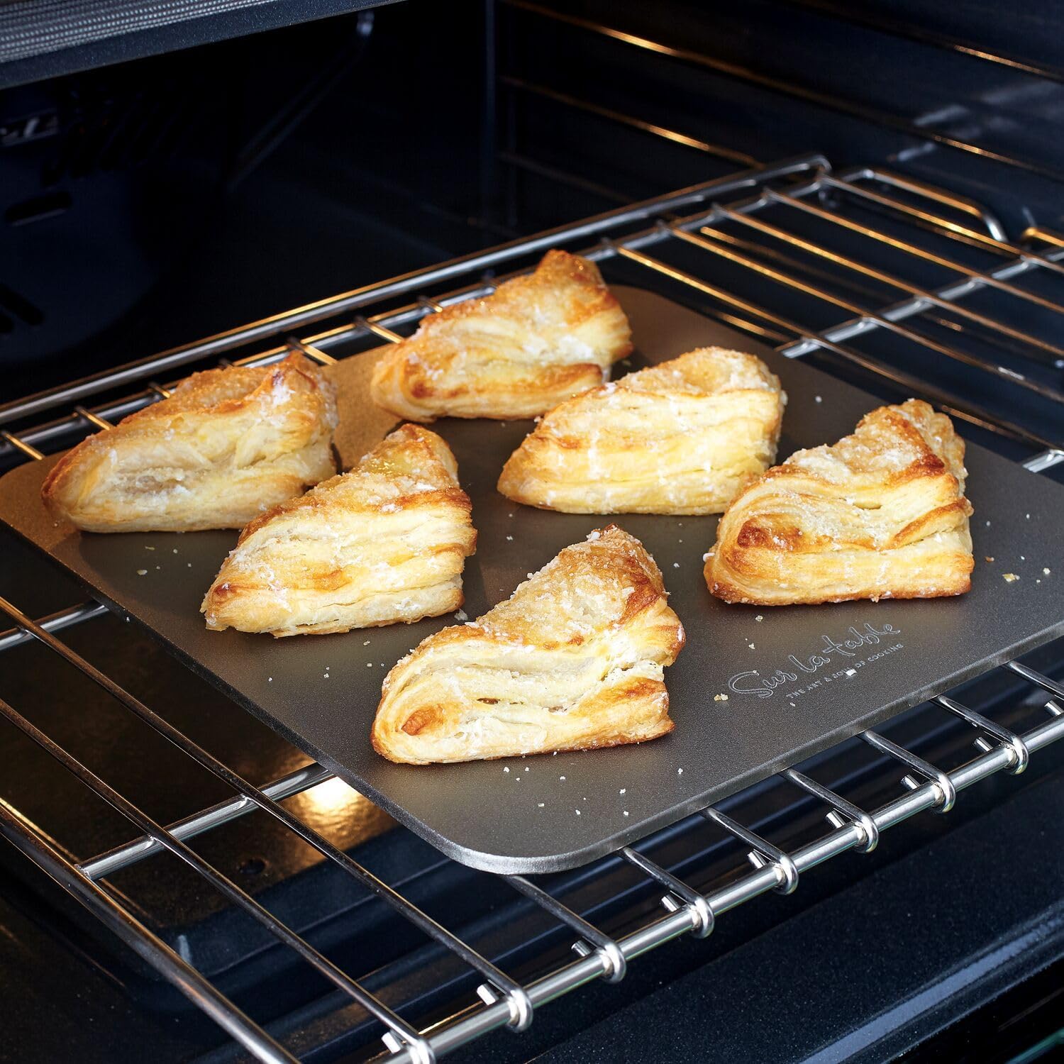 Puff pastry turnovers baking on the Sur La Table Baking Steel inside an oven.