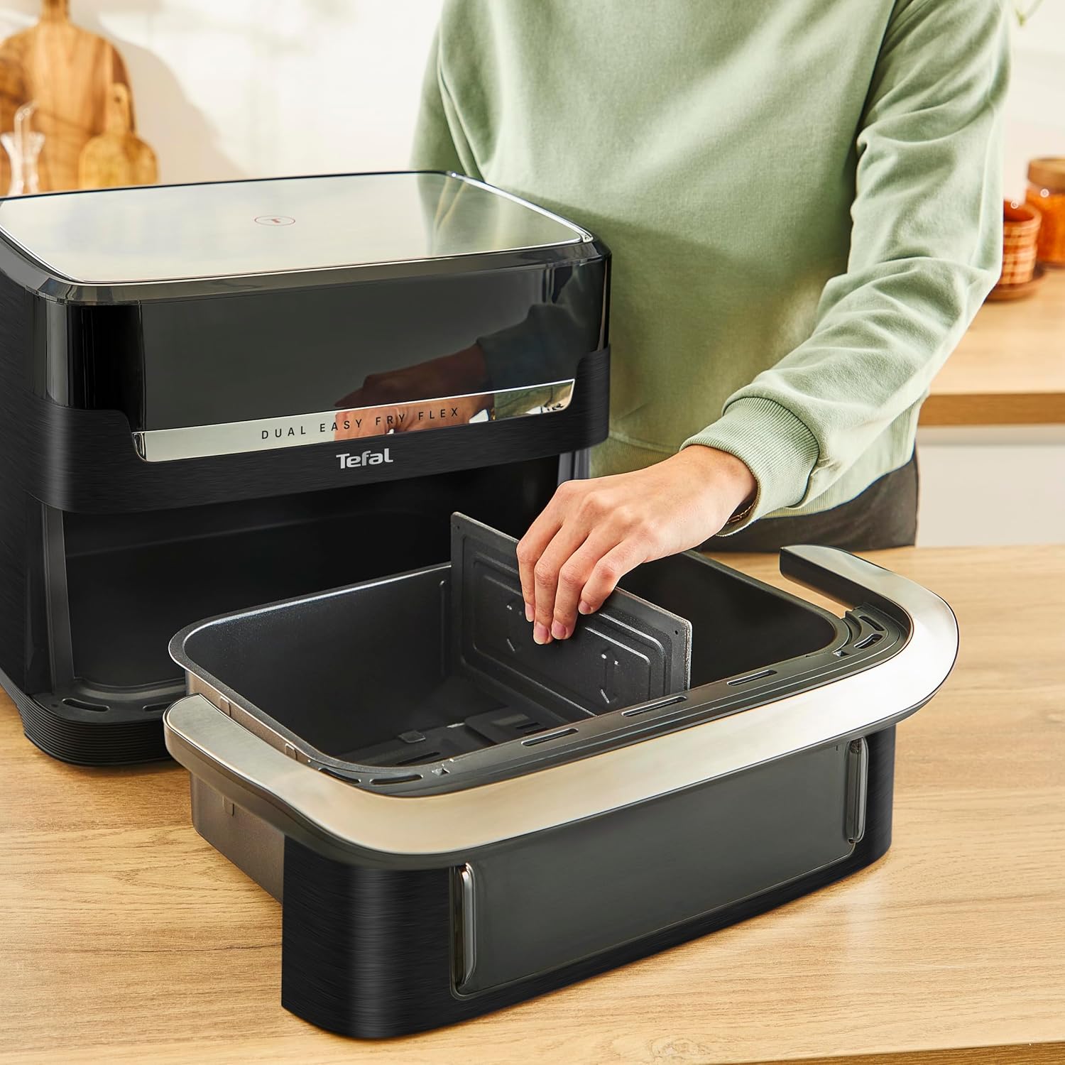 Hand inserting the FlexCook divider into the air fryer basket