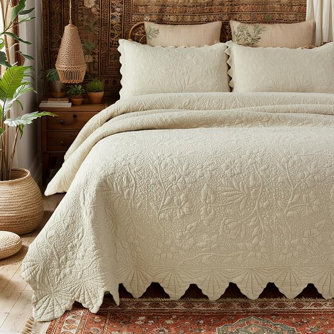 Soft neutral quilted bedding with layered pillows on wooden bed frame