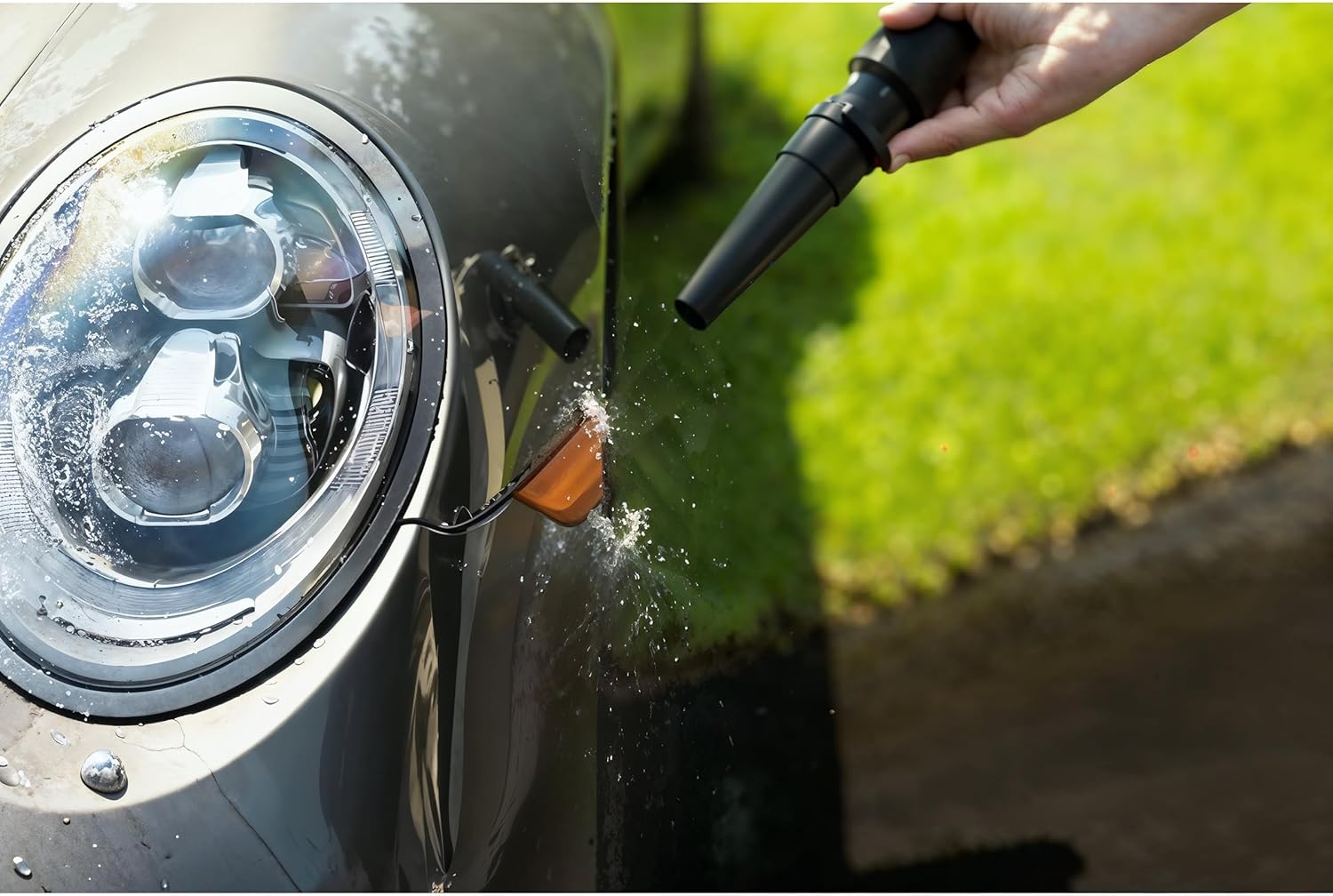 A person using the claw-type upholstery tool of the MetroVac Super Vac N Blaster to vacuum a car's floor mat.