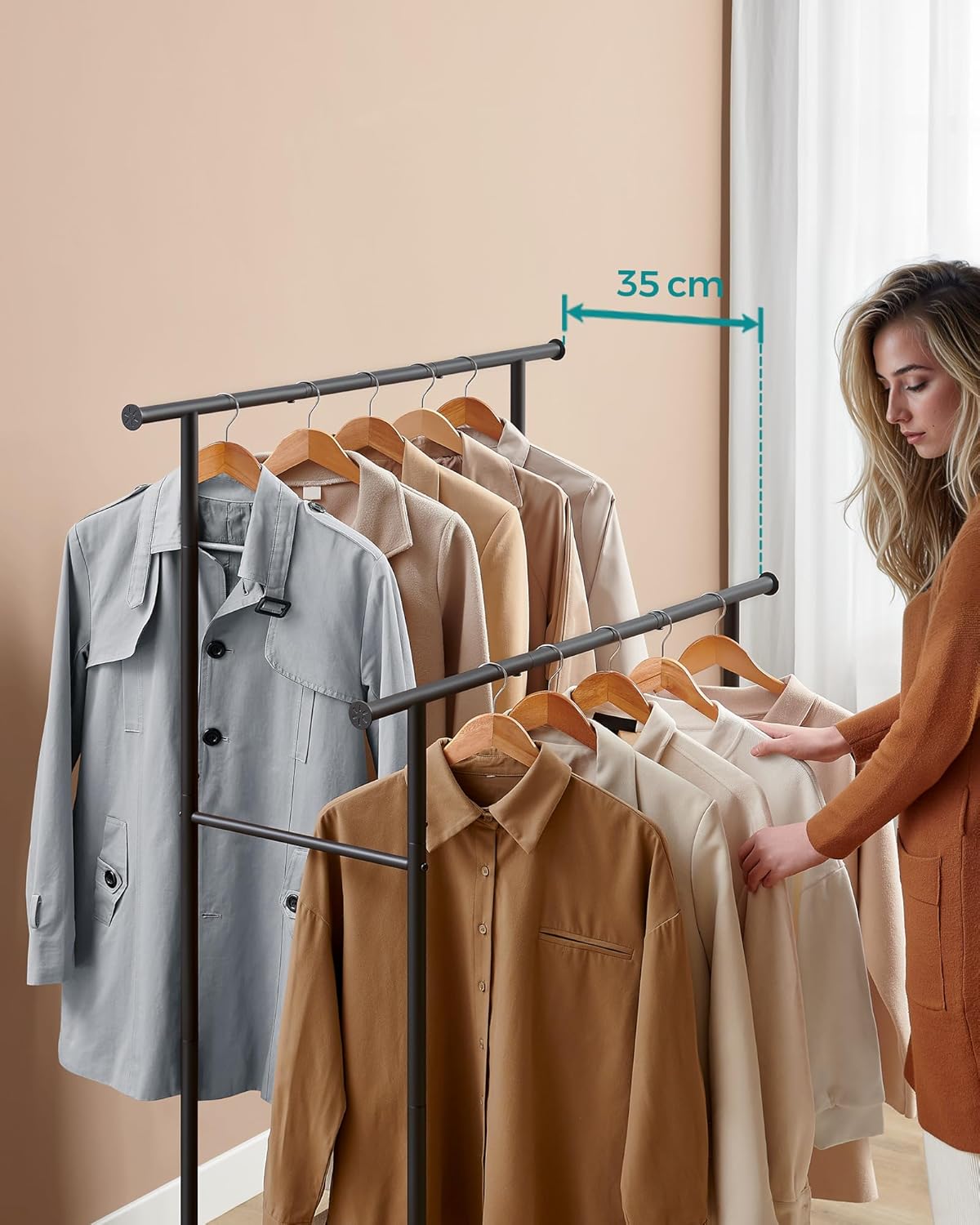A woman adjusting clothes on the lower bar of the coat rack, with a measurement indicating a 35 cm gap between the two hanging bars.