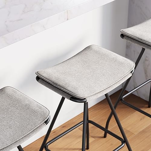 Miniatura 22 de Nathan James 22201 Arlo - Taburete de bar tapizado moderno sin espalda con asiento de sillín de doble capa y base de metal, gris/negro mate Plumas