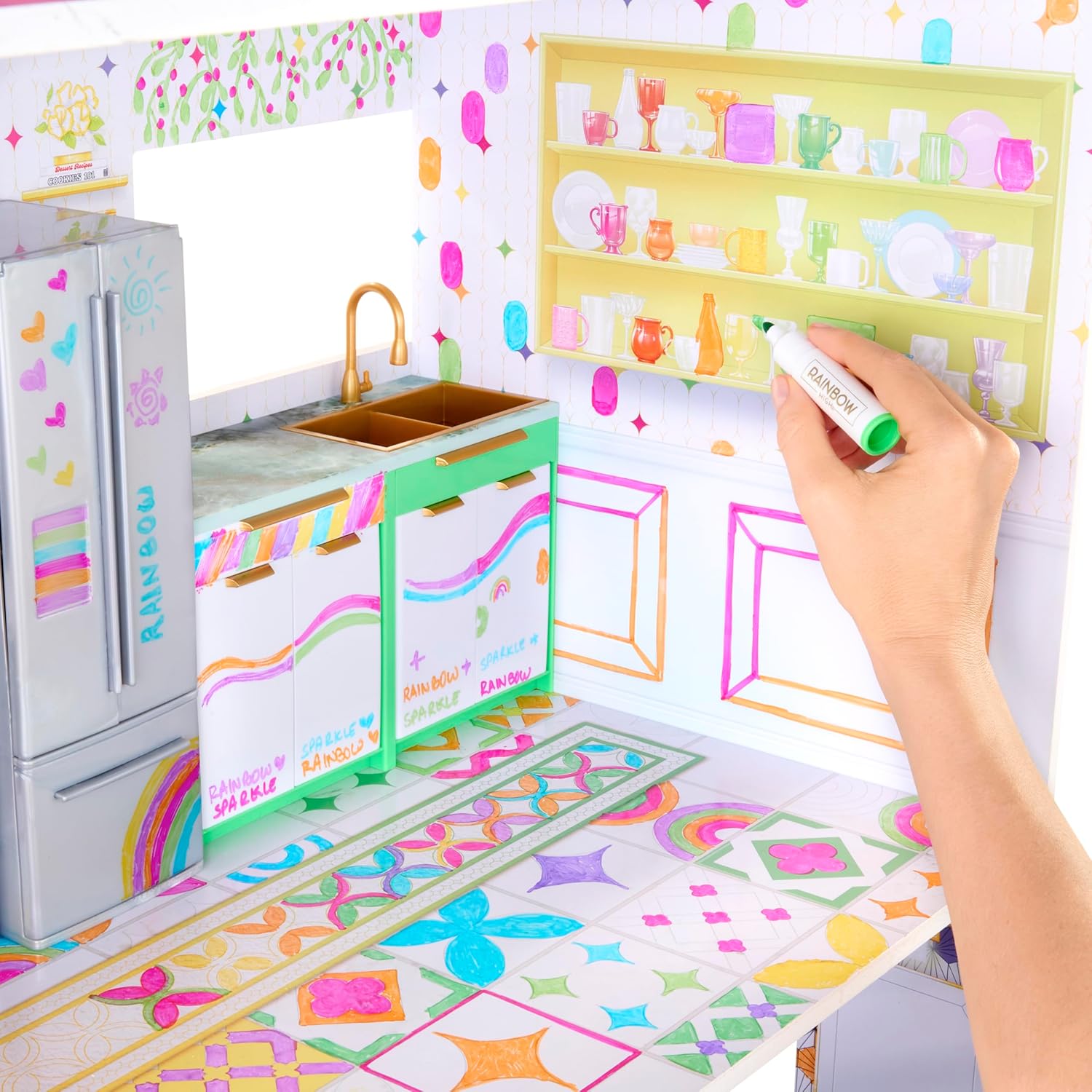 A hand coloring the kitchen floor of the dollhouse with a green washable marker.