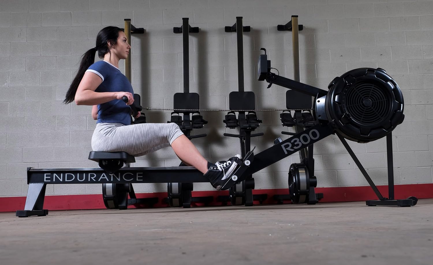 Woman demonstrating proper rowing form on Body-Solid R300