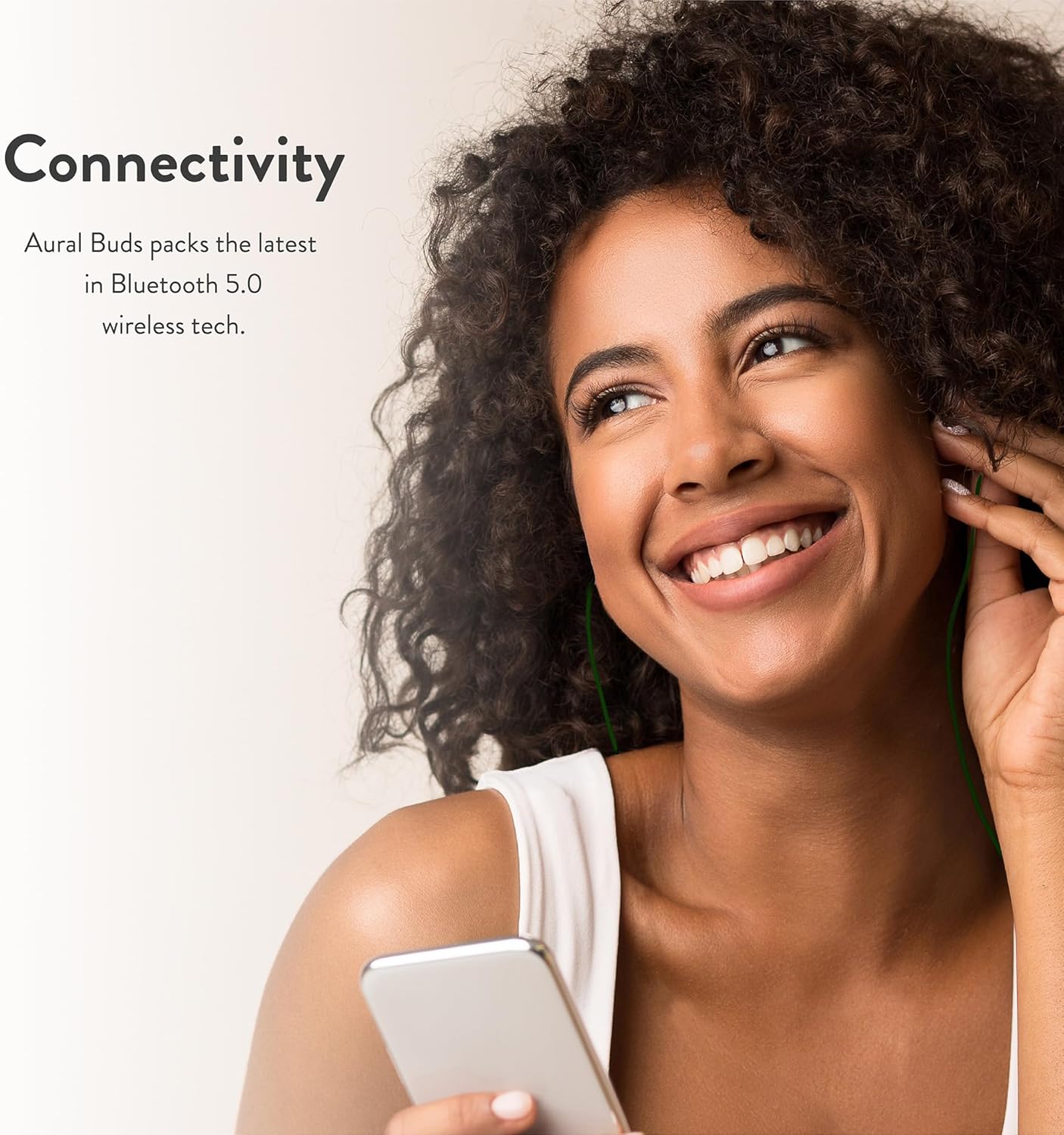 Frau lächelt, trägt Bitmore Aural Buds und hält ein Smartphone in der Hand