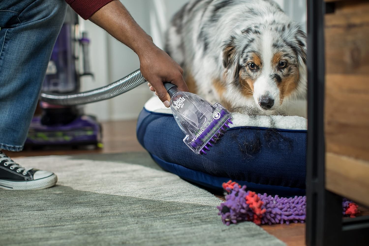 Hand using the Pet Turbo Tool of the Dirt Devil Power Max Rewind Pet Upright Vacuum on a pet bed
