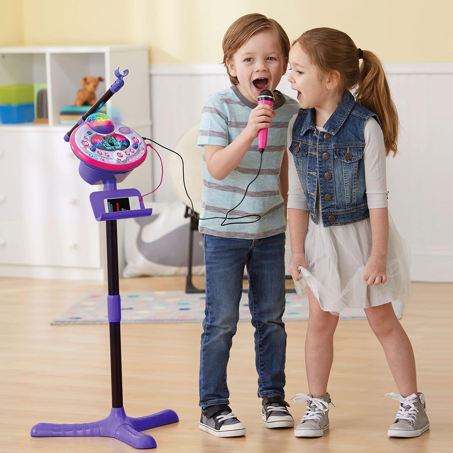 Child singing with the VTech Kidi Star Karaoke Machine, showing colorful disco lights projected in the background