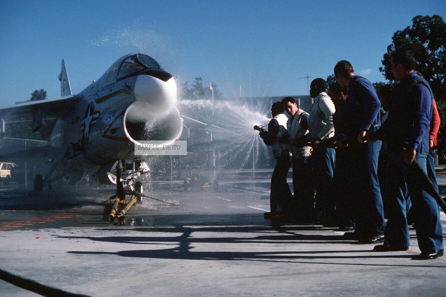 Photo Students hose down an A7 Corsair II aircraft during