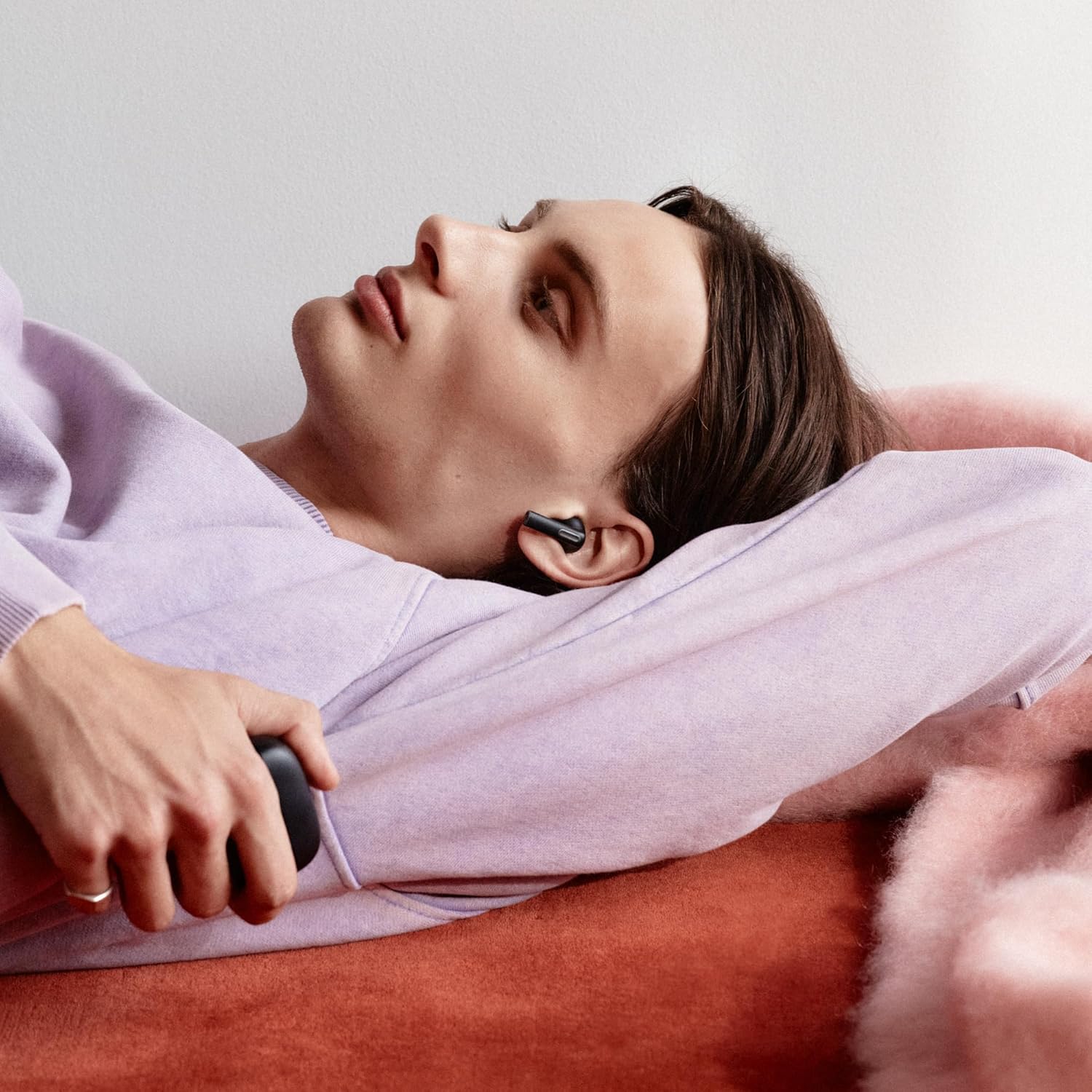 Person comfortably wearing a Sudio A1 Pro earbud while relaxing.