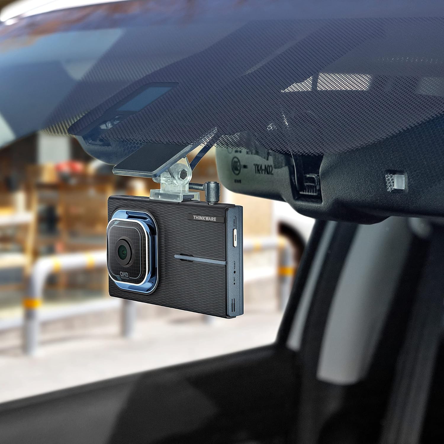 Thinkware X1000 Dash Cam mounted on a car windshield, viewed బయట నుండి.