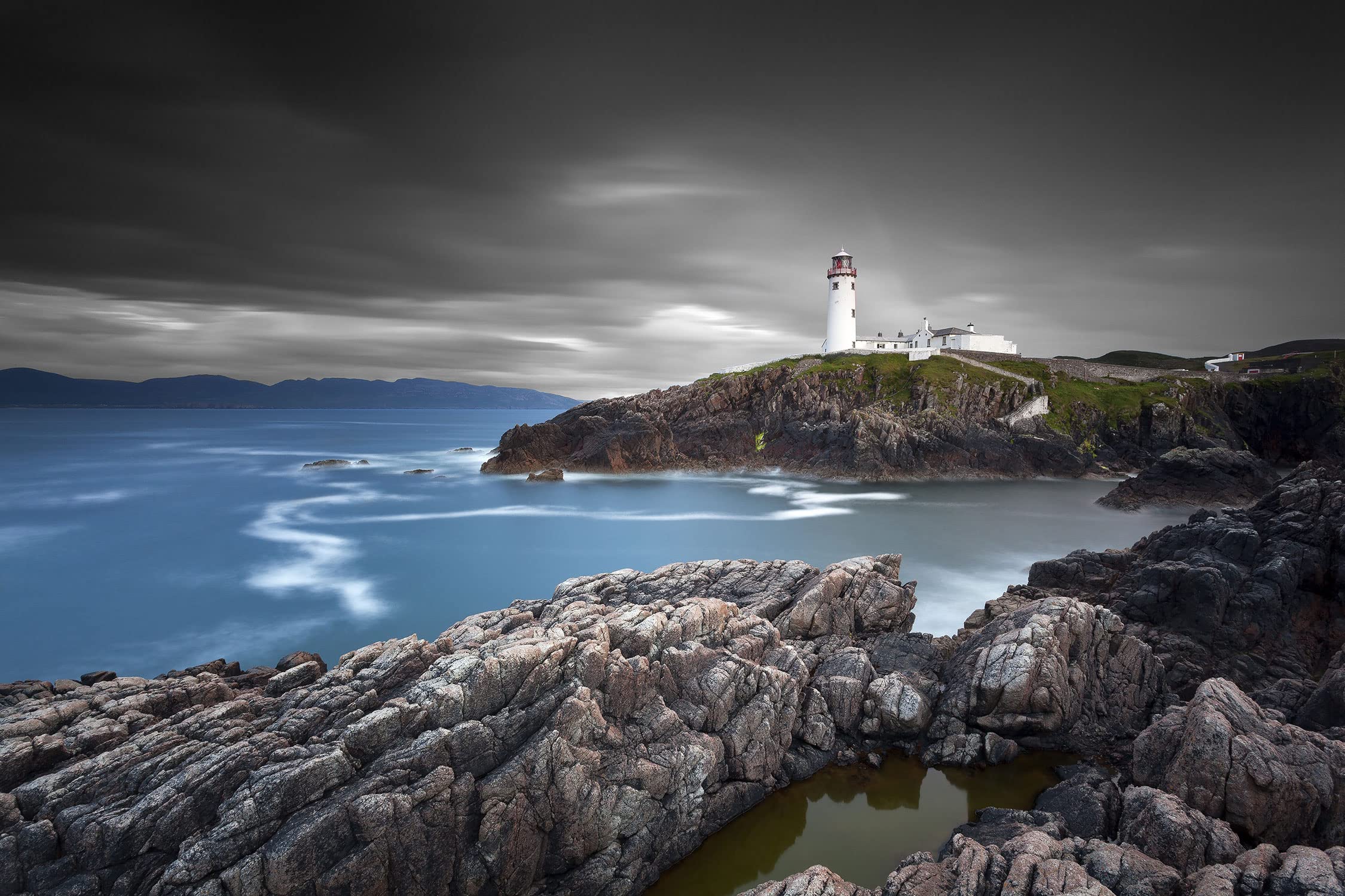 Murale in vero vetro | Minuscolo faro su rocce | 120 x 50 cm