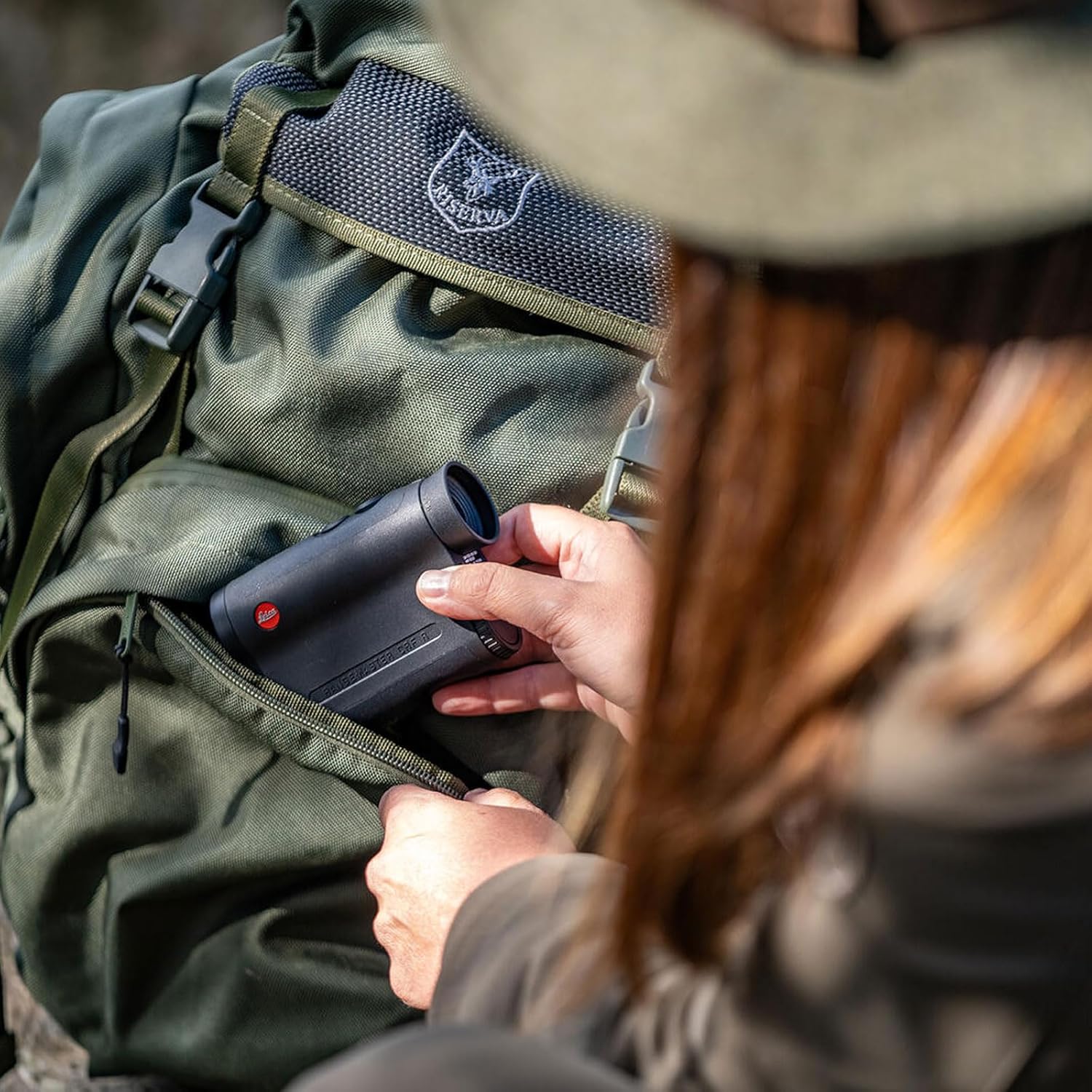 User holding Leica Rangemaster CRF-R Laser Rangefinder in a hunting environment