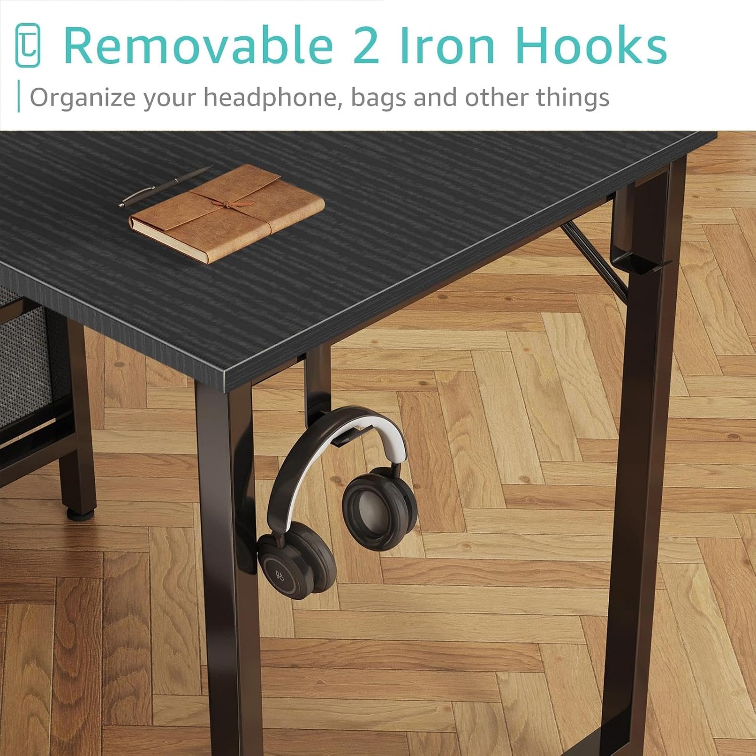 Close-up of the desk's side, showing a removable iron hook holding a pair of headphones.