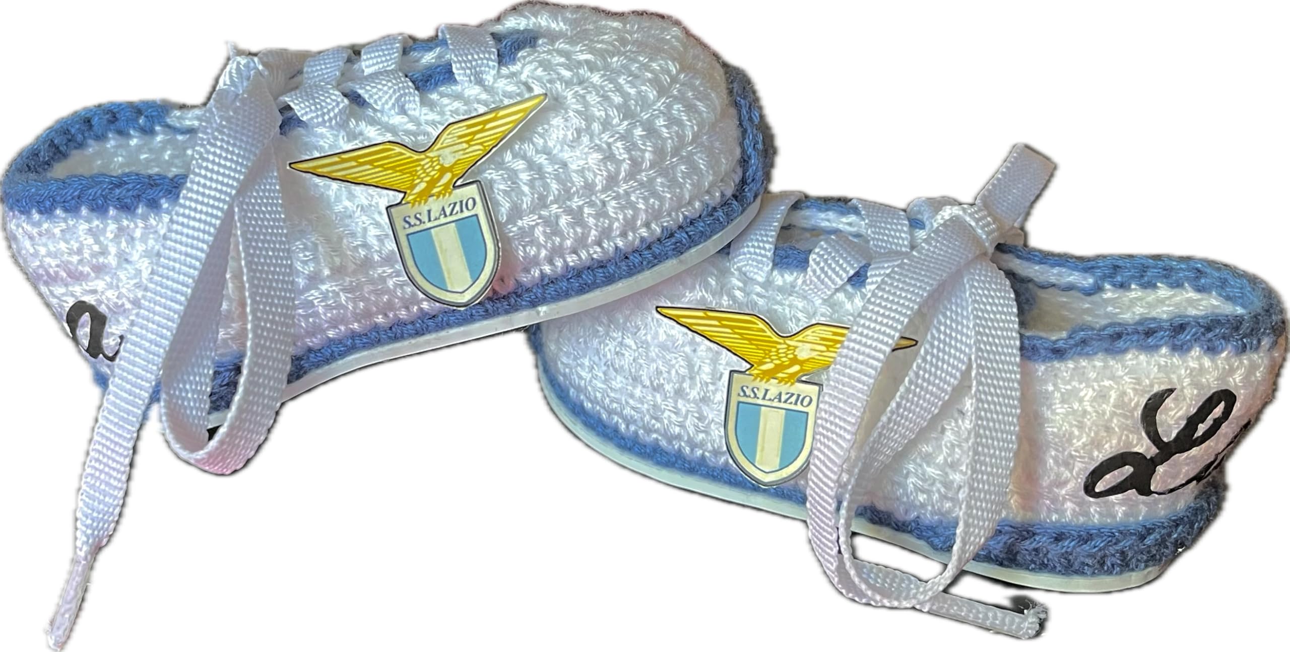 Scarpini da calcio del Lazio realizzati all'uncinetto per neonati. Personalizzato con lo stemma della tua squadra, disponibile nelle taglie da 0 a 12 mesi. Ti regaliamo il nome del bambino inciso