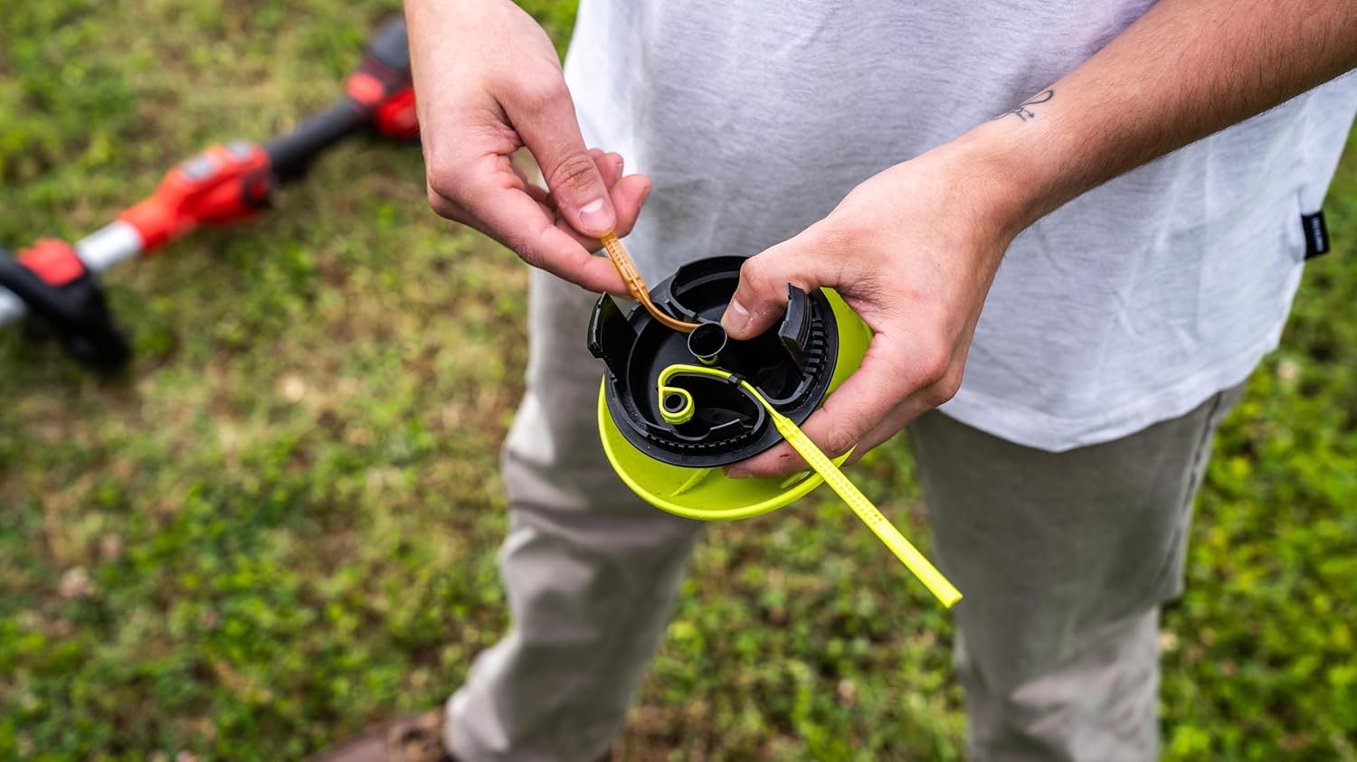 Hands demonstrating the easy reloading process of the flexible blades into the trimmer head.