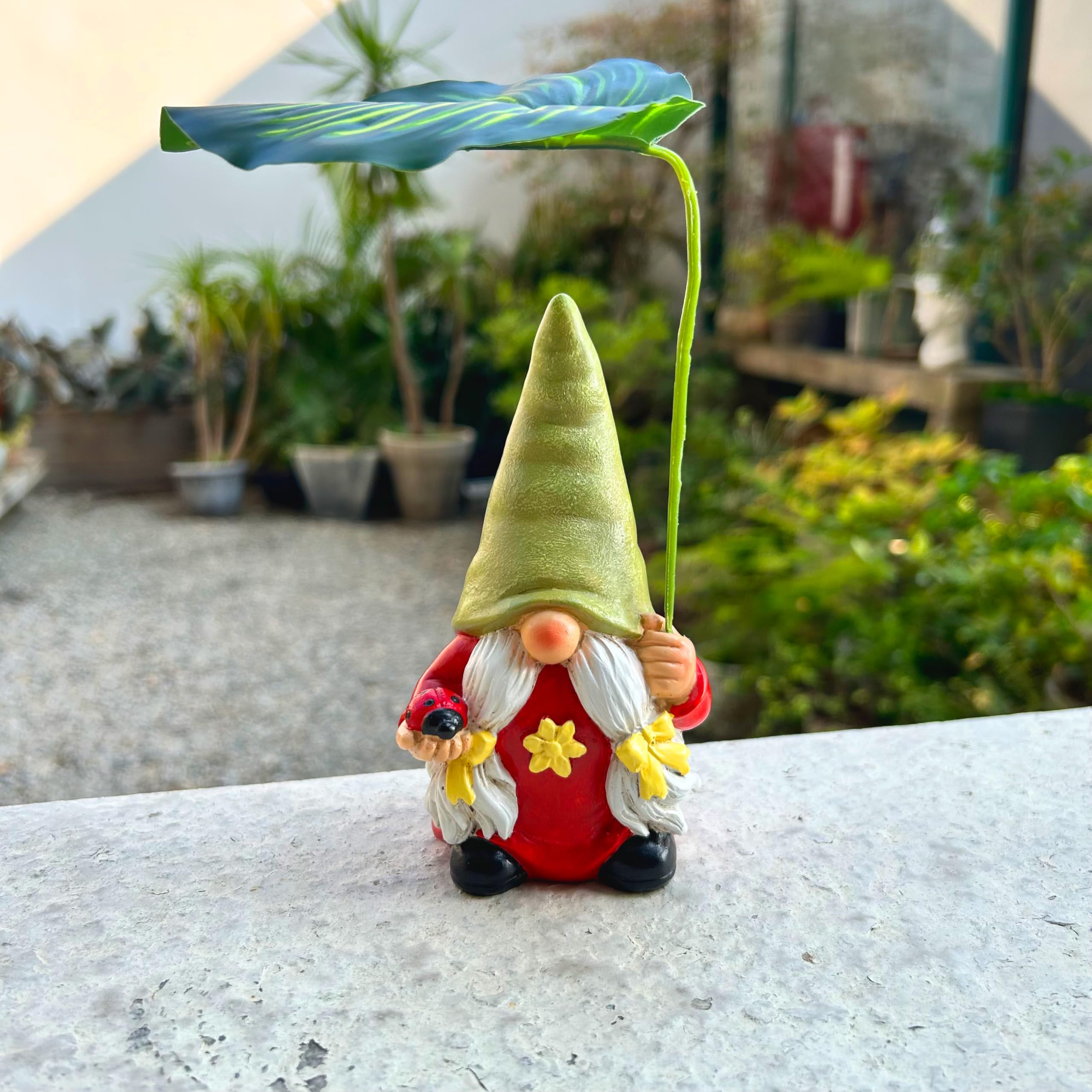 Gnomo de jardín con paraguas de hojas, figura decorativa, rojo y verde, con mariquita sosteniendo