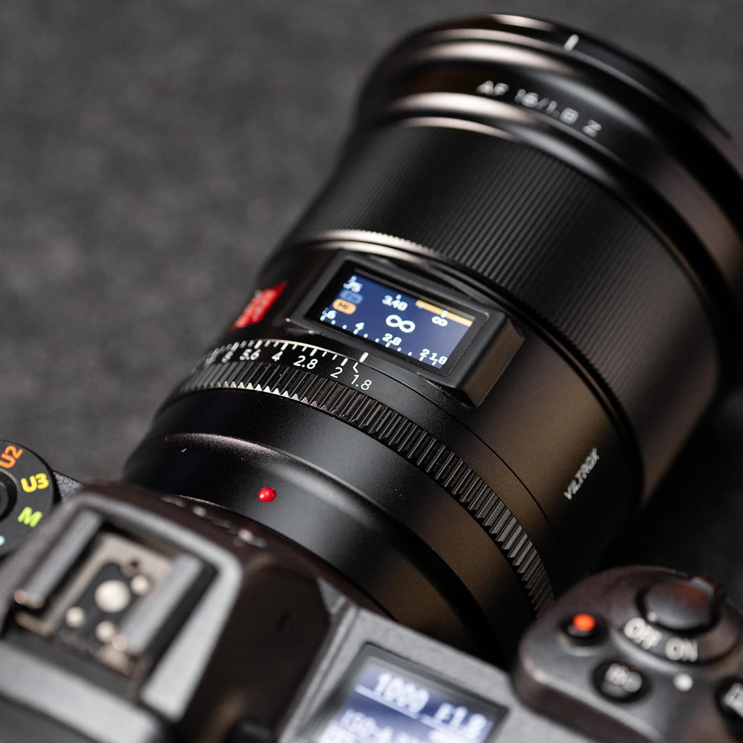 Close-up of the VILTROX AF 16mm f/1.8 Z lens LCD screen displaying aperture and focus distance information.
