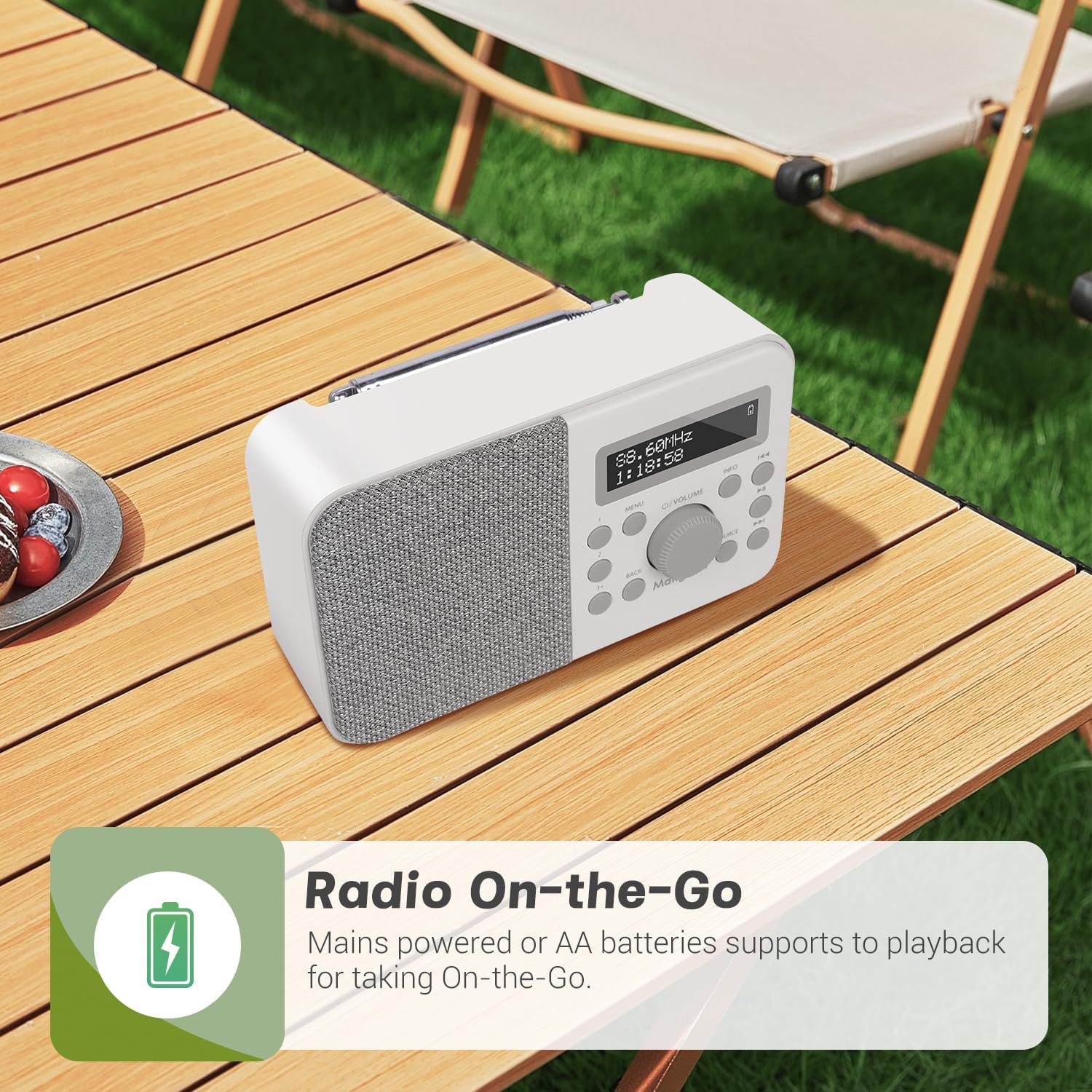 MangoKit PR2S radio on an outdoor wooden table, illustrating its portability with mains and battery power options.