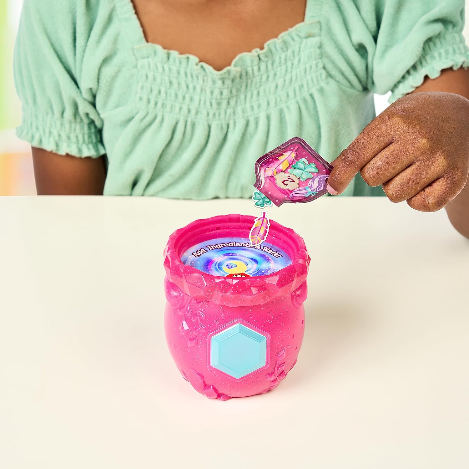 Child adding the first ingredient packet into the Magic Mixies cauldron