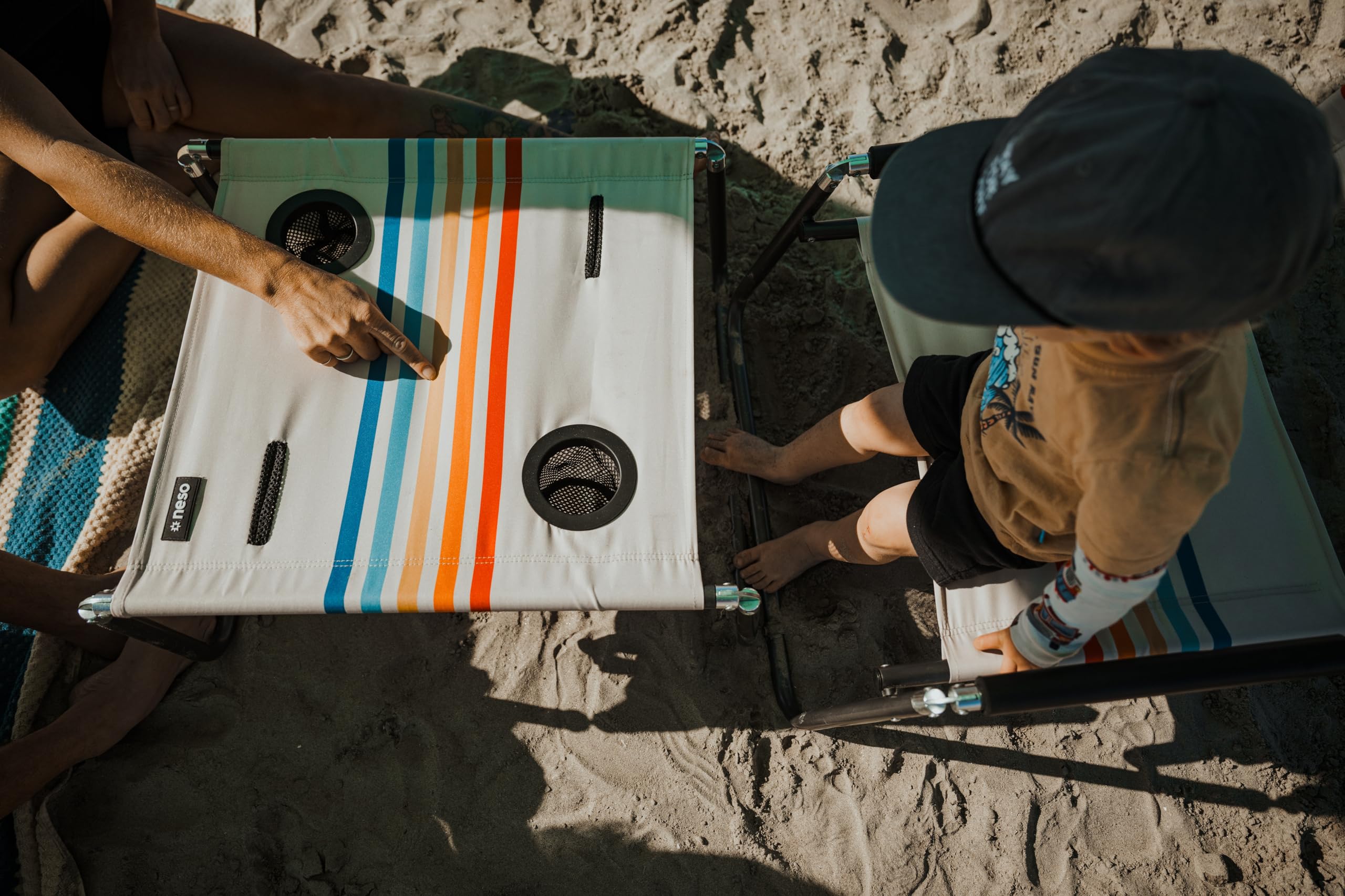 Neso Tavolo da spiaggia, leggero, portatile e pieghevole, per spiaggia, campeggio e avventure all'aria aperta, superficie stabile, con portabicchieri per bevande e tasche per telefono, arcobaleno