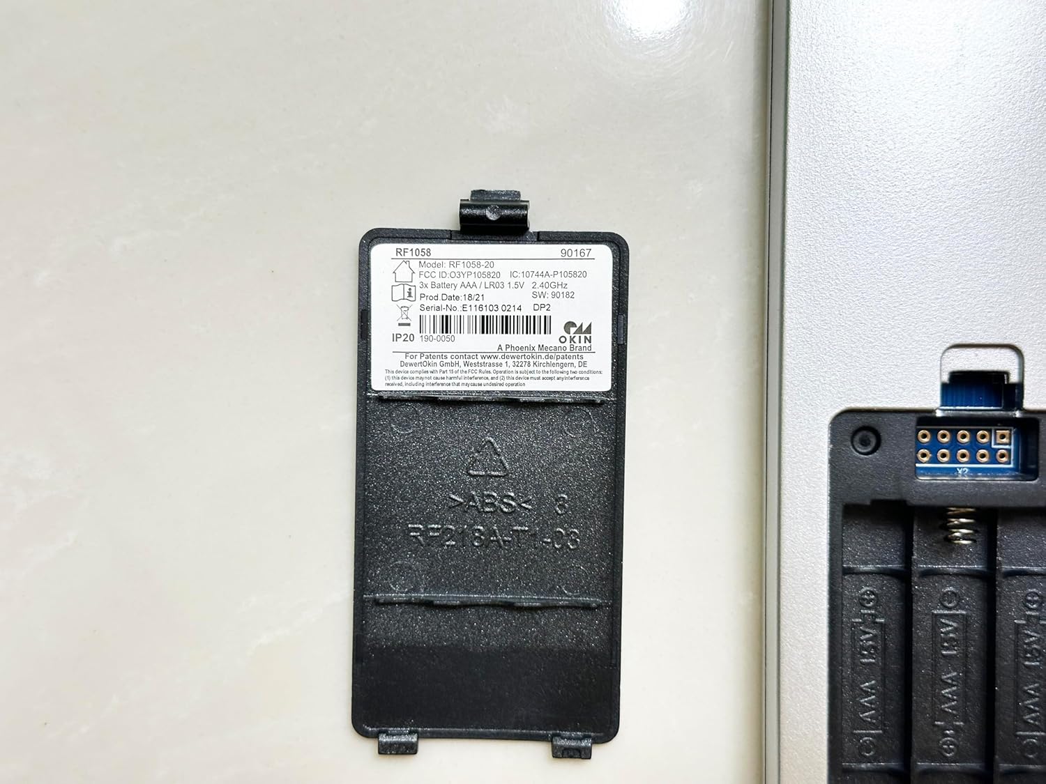 Close-up of the RF1058-20 battery compartment cover with model and regulatory details.