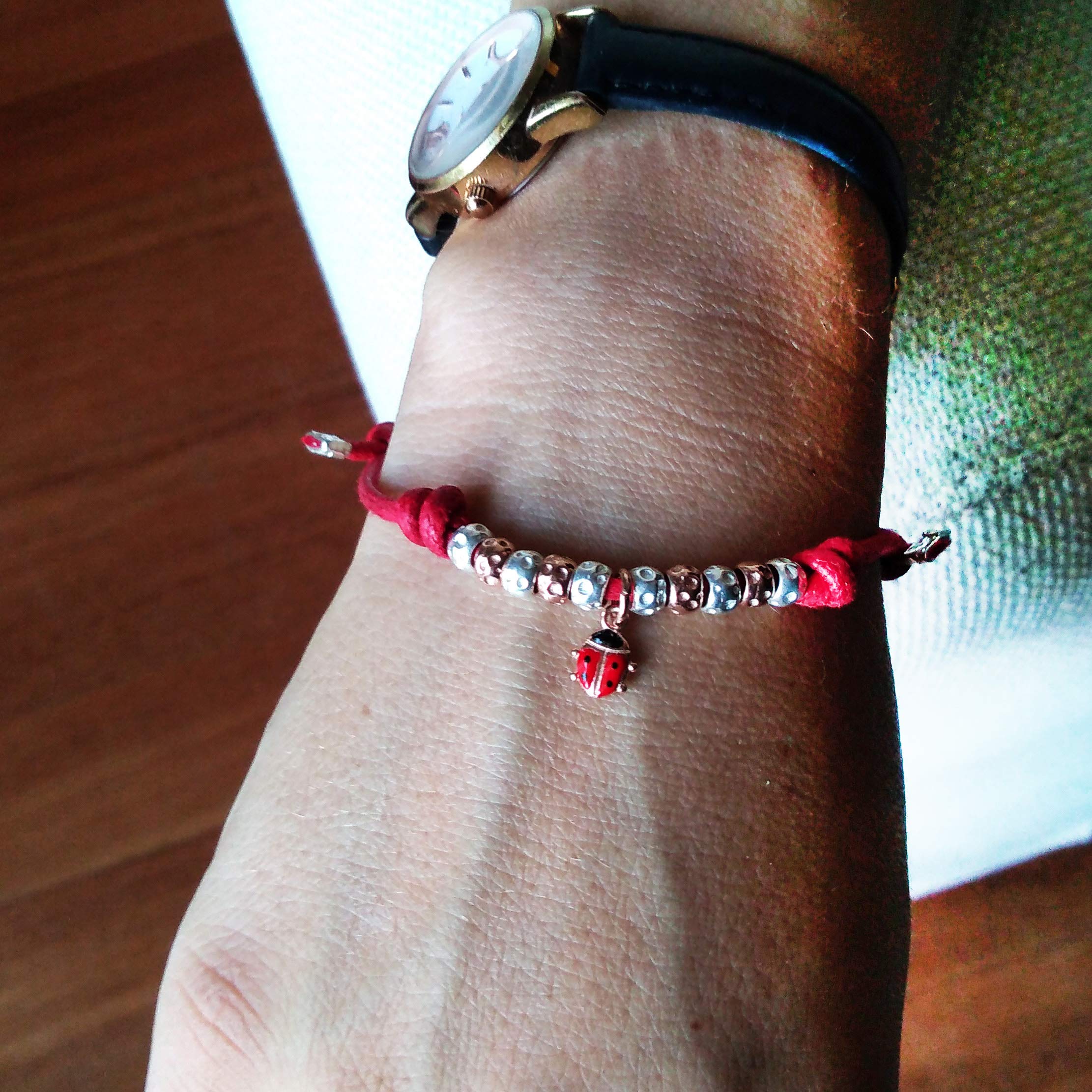 BRACCIALETTO CORDINO ROSSO con COCCINELLA SMALATATA e GRANELLI martellati in ARGENTO 925