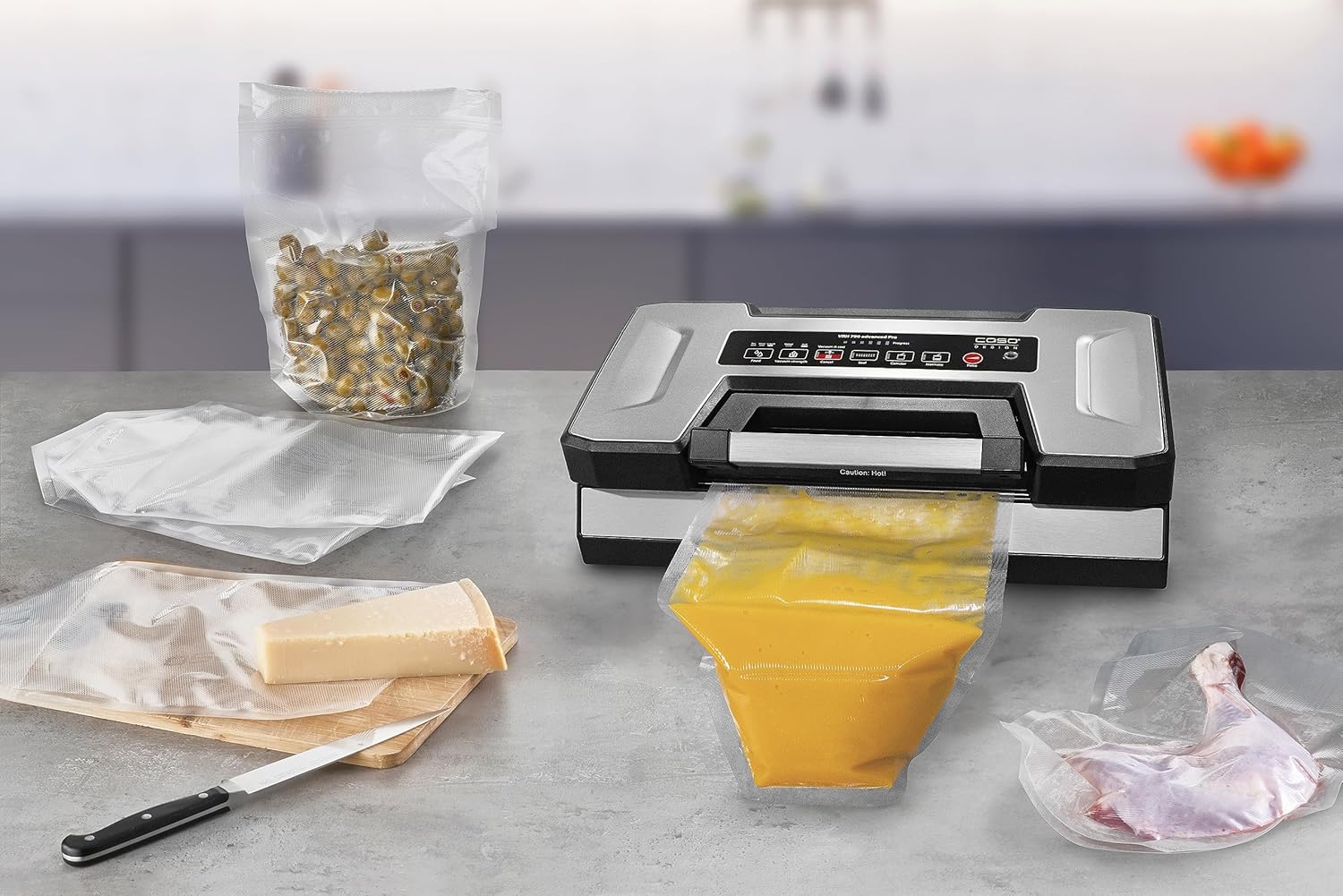 Various food items, including a bag of liquid soup, cheese, and poultry, ready for vacuum sealing with the CASO VRH 790 advanced Pro