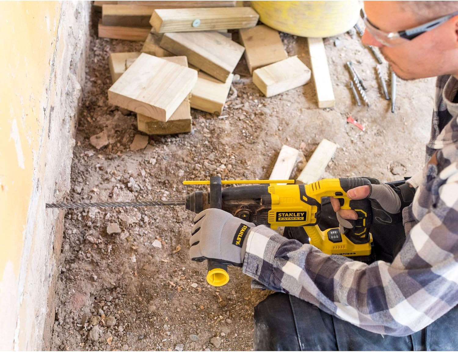 User operating STANLEY hammer drill for drilling into a wall