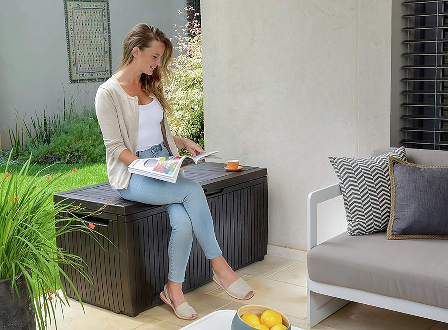 Person sitting on the Keter Springwood Storage Box, demonstrating seating capacity