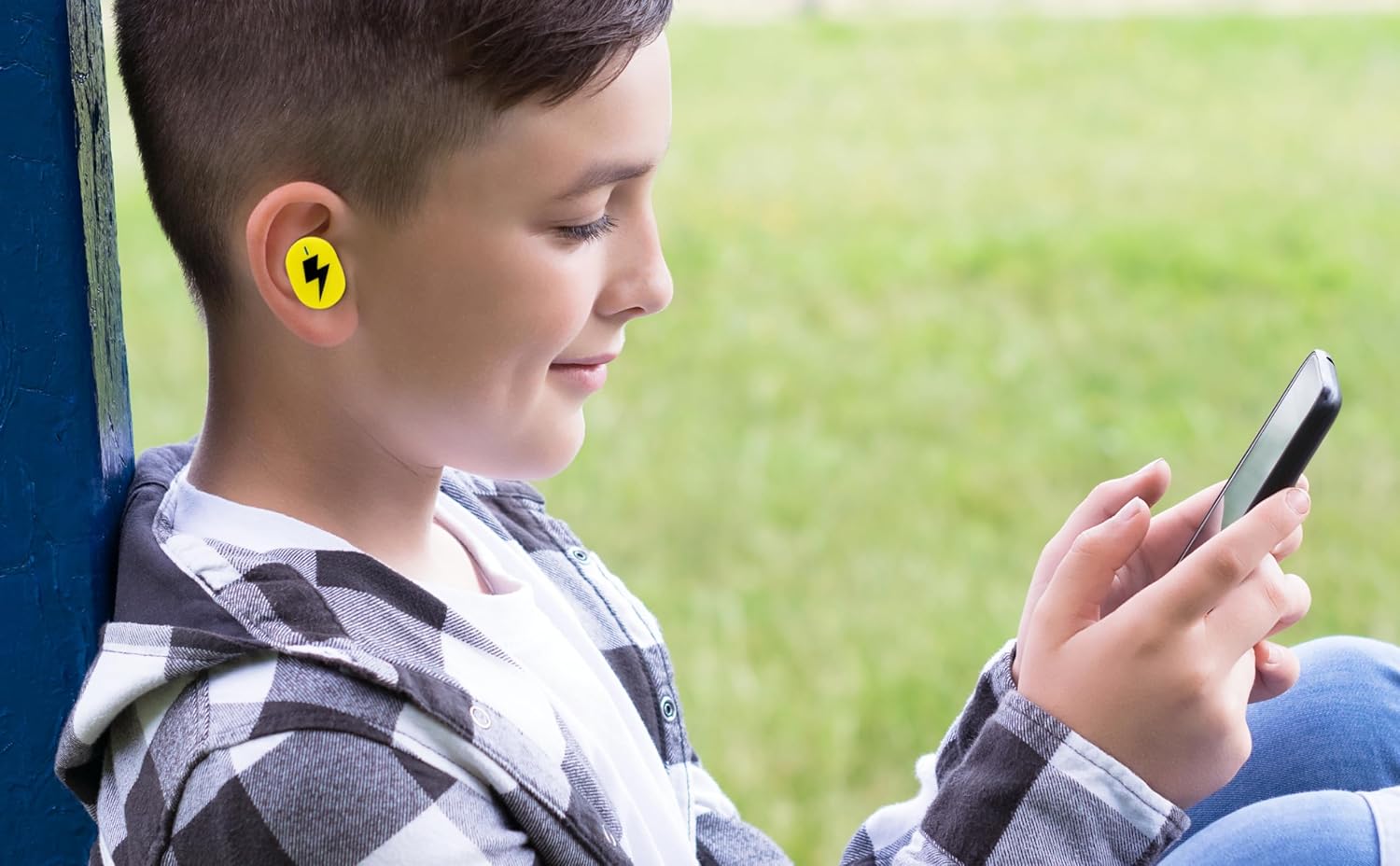 A child wearing the eKids Pokemon Earbuds while looking at a smartphone
