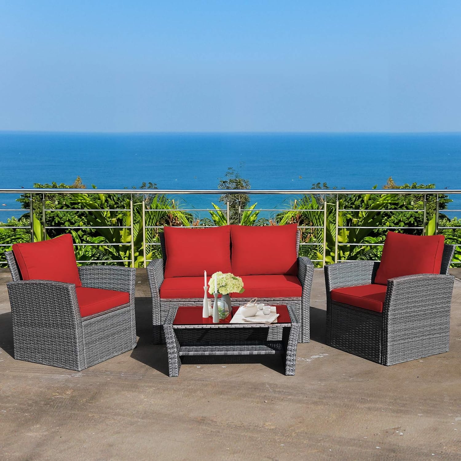 Patio furniture set on a balcony overlooking the ocean.