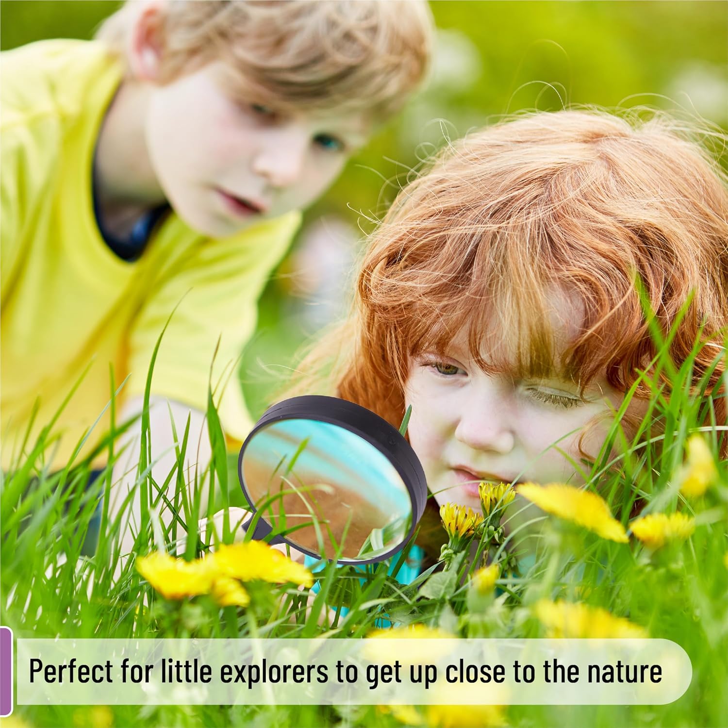 Child using a magnifying glass to examine a plant outdoors.
