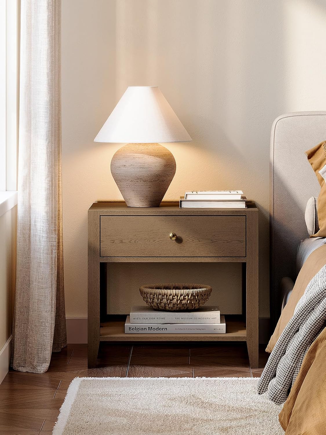 ModernMate end table used as a nightstand in a bedroom, with a lamp, books, and a picture frame on top.