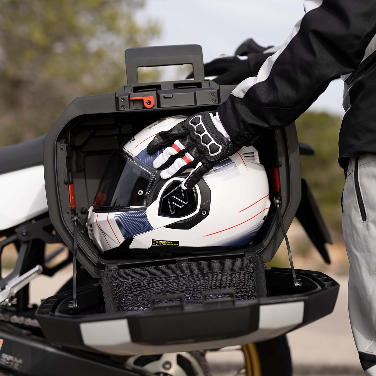 Person placing a white system helmet into an open SHAD SH38X side case