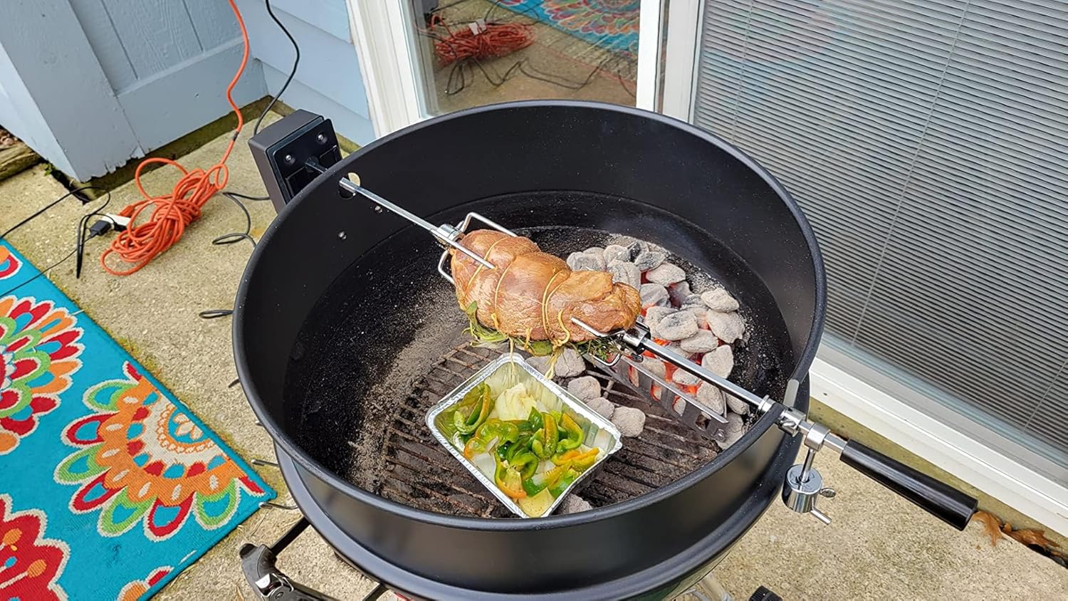 Rotisserie motor in action on a grill with food