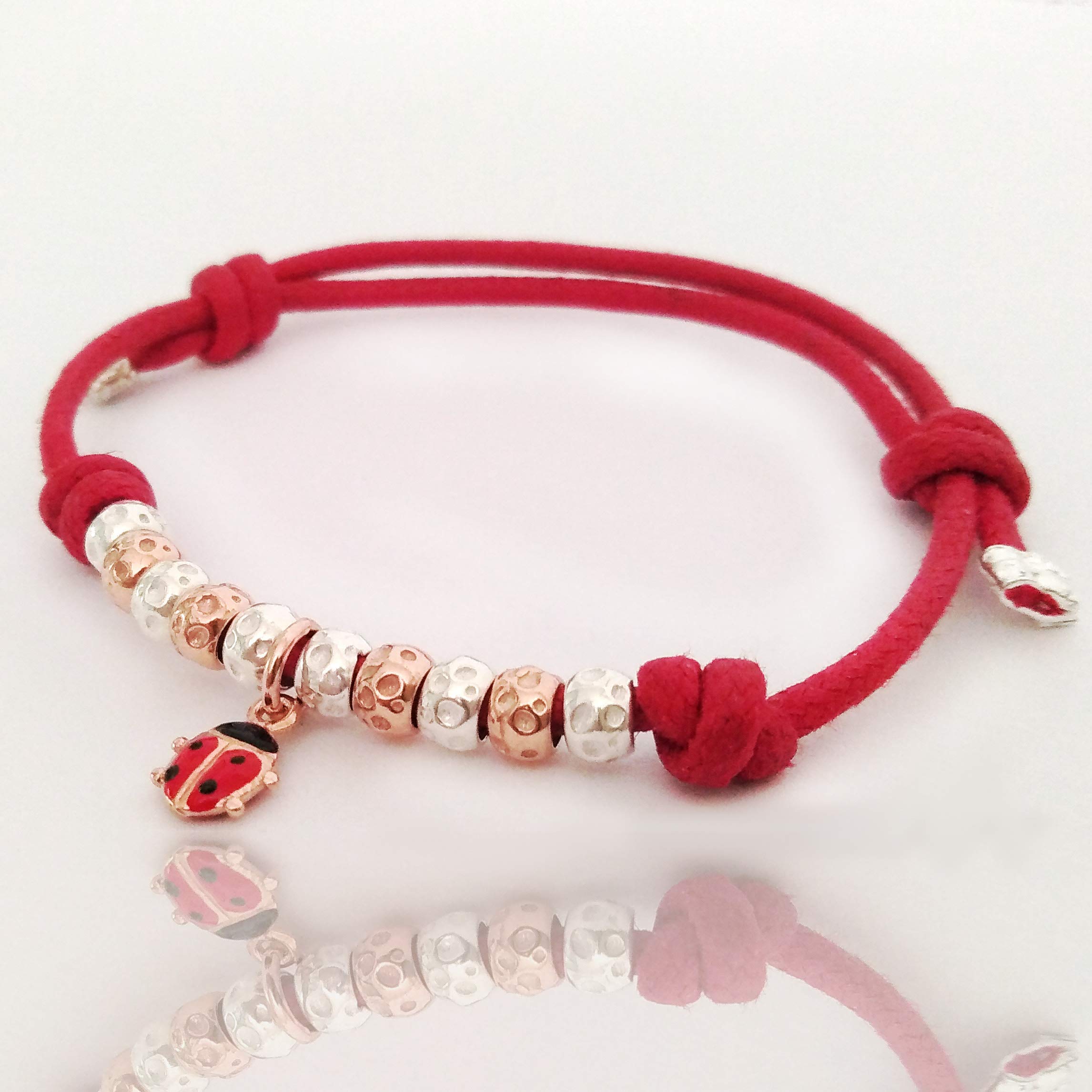 BRACCIALETTO CORDINO ROSSO con COCCINELLA SMALATATA e GRANELLI martellati in ARGENTO 925