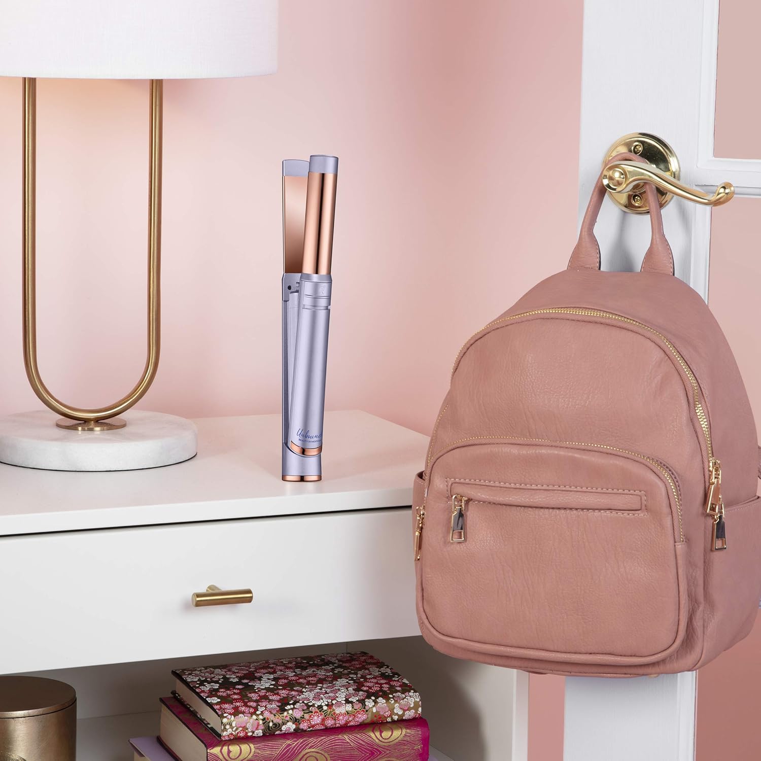 Conair Unbound Multi-Styler placed on a desk next to a backpack, illustrating its portability