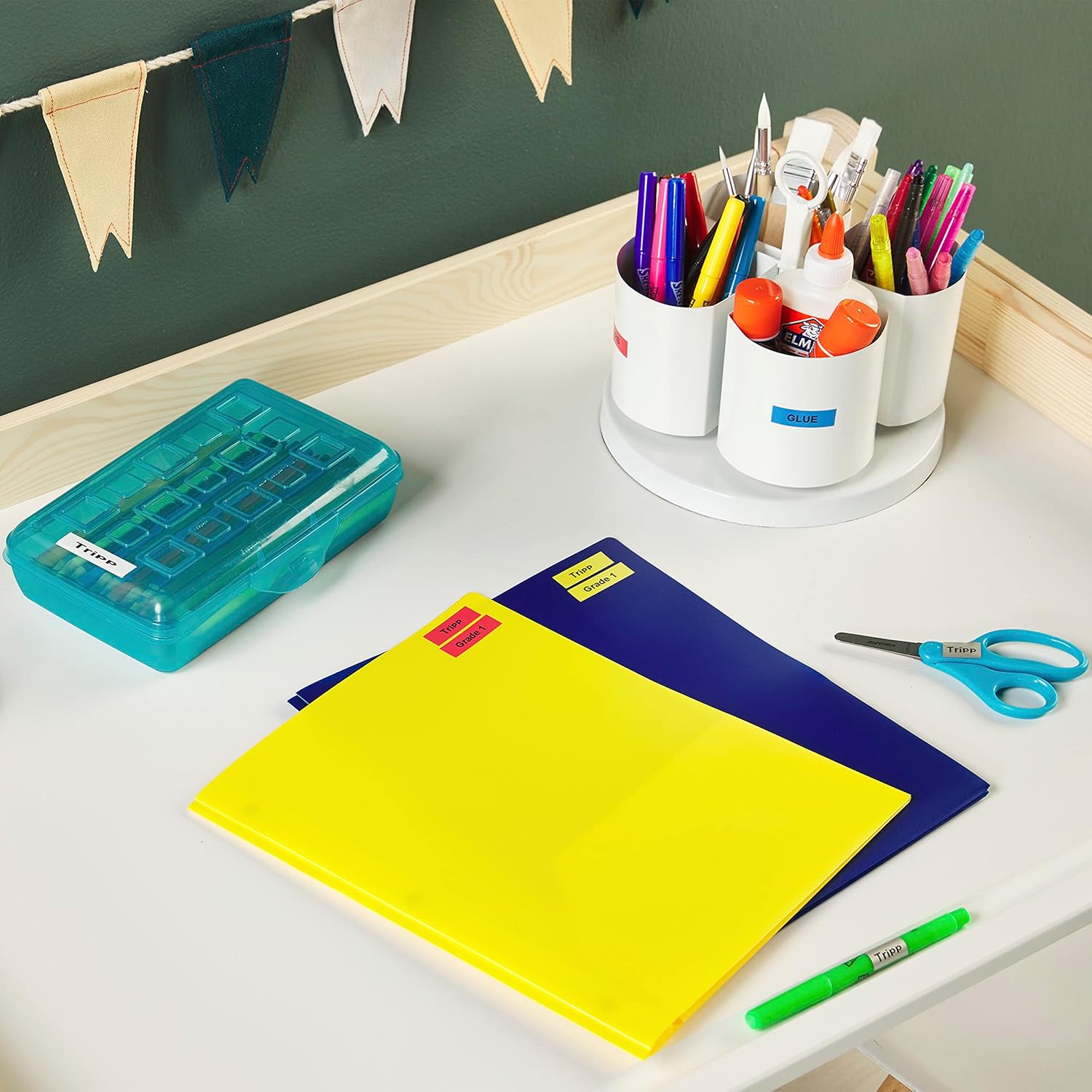 Desk with labeled school supplies and folders.