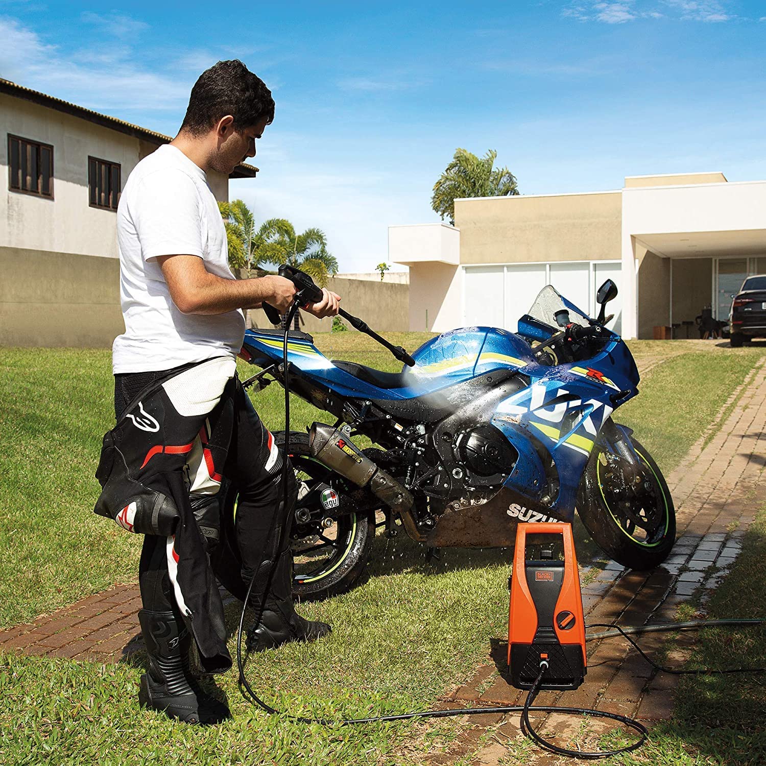 Man using BLACK+DECKER pressure washer to clean a motorcycle
