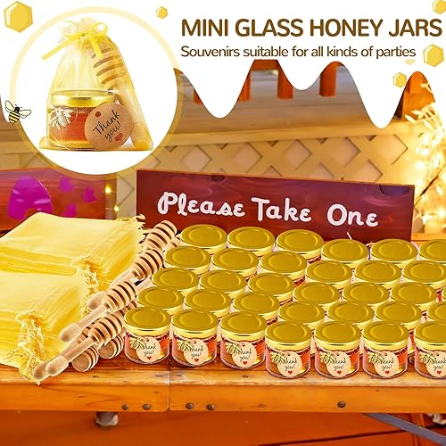 Miniatura 4 de 50 tarros pequeños de vidrio de 1 onza con tapas, mini tarros de miel con cuchara de madera, dijes de abeja, bolsas de regalo doradas, yutes y