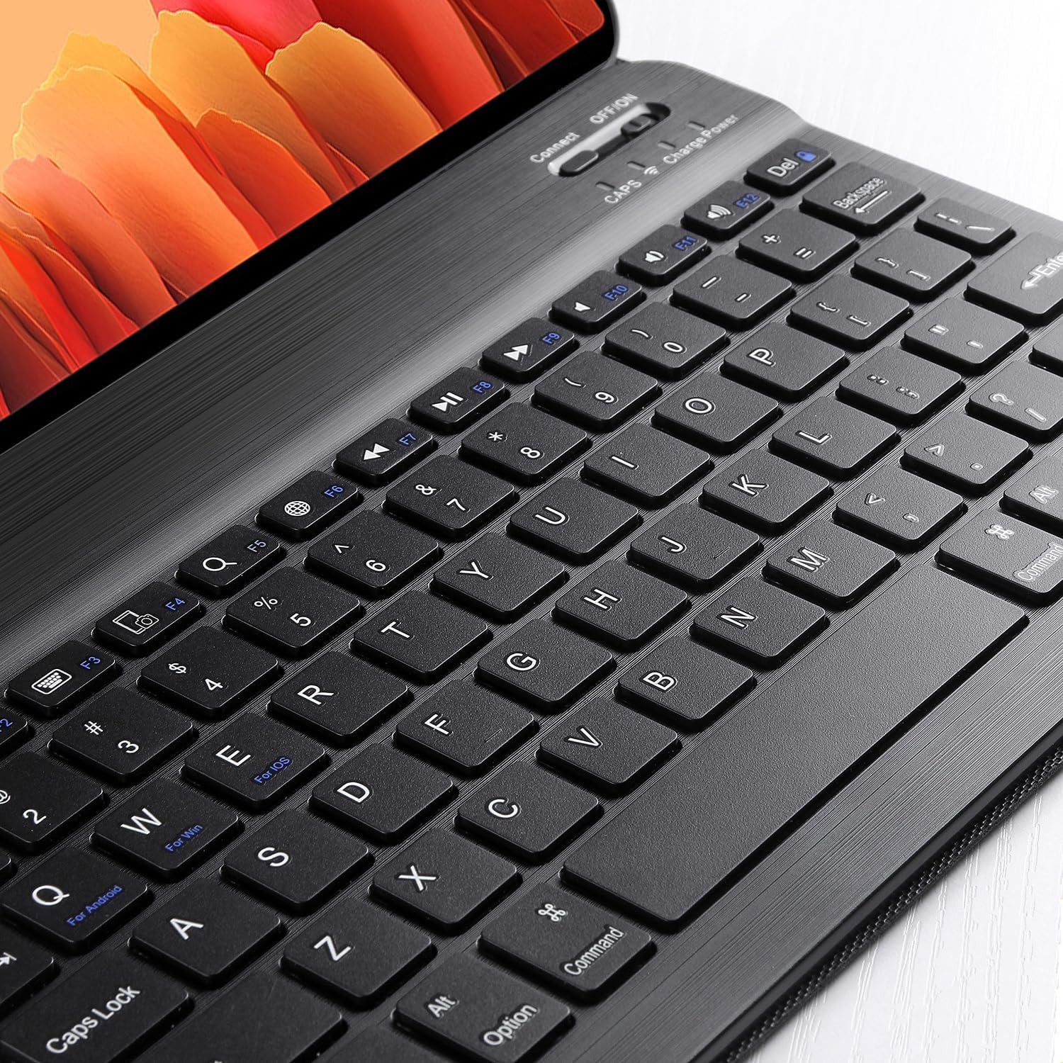 Angled close-up view of the Bluetooth keyboard, showing the QWERTY layout and function keys.