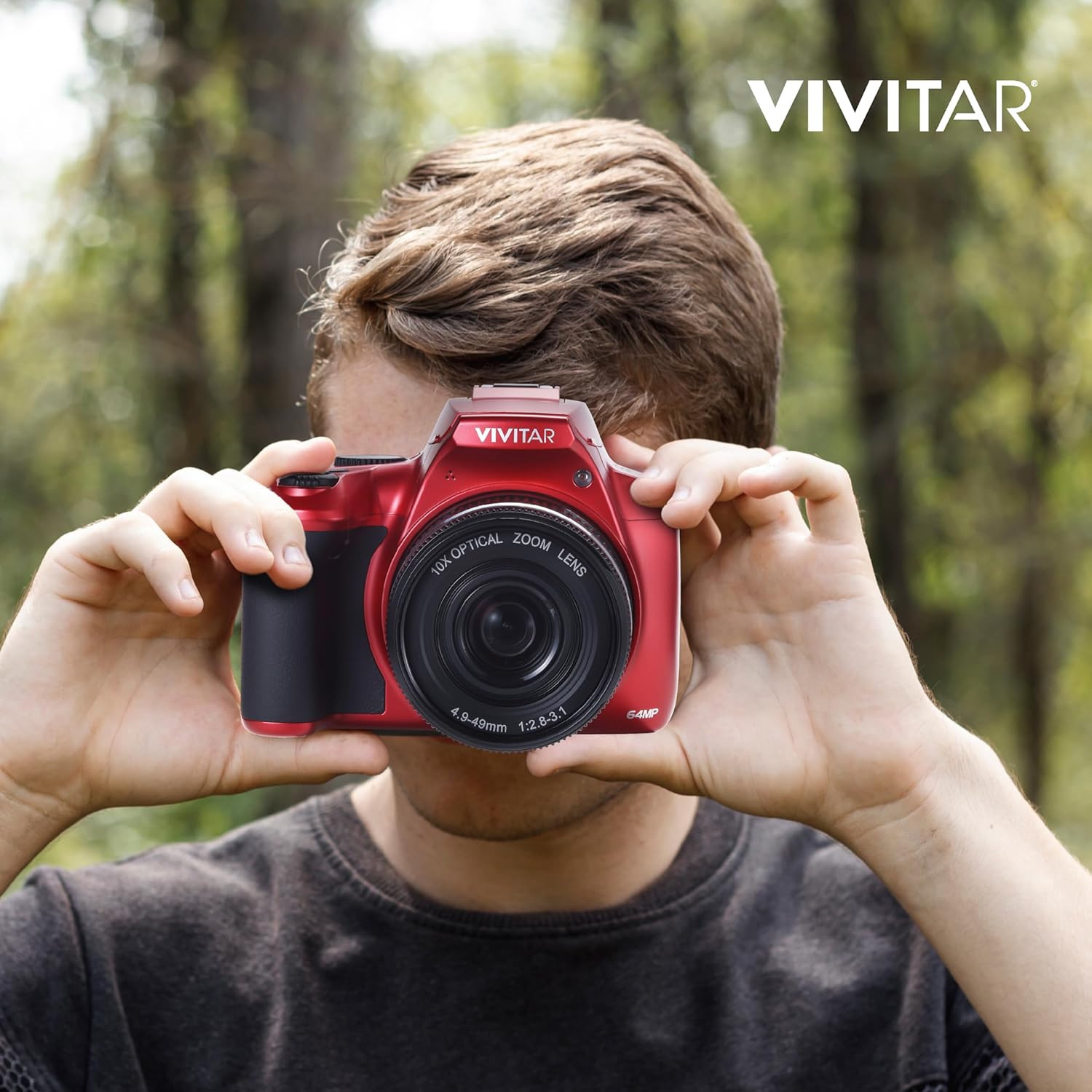 A person holding the Vivitar 4K Digital Camera from behind, showing the LCD screen, with a blurred outdoor background.