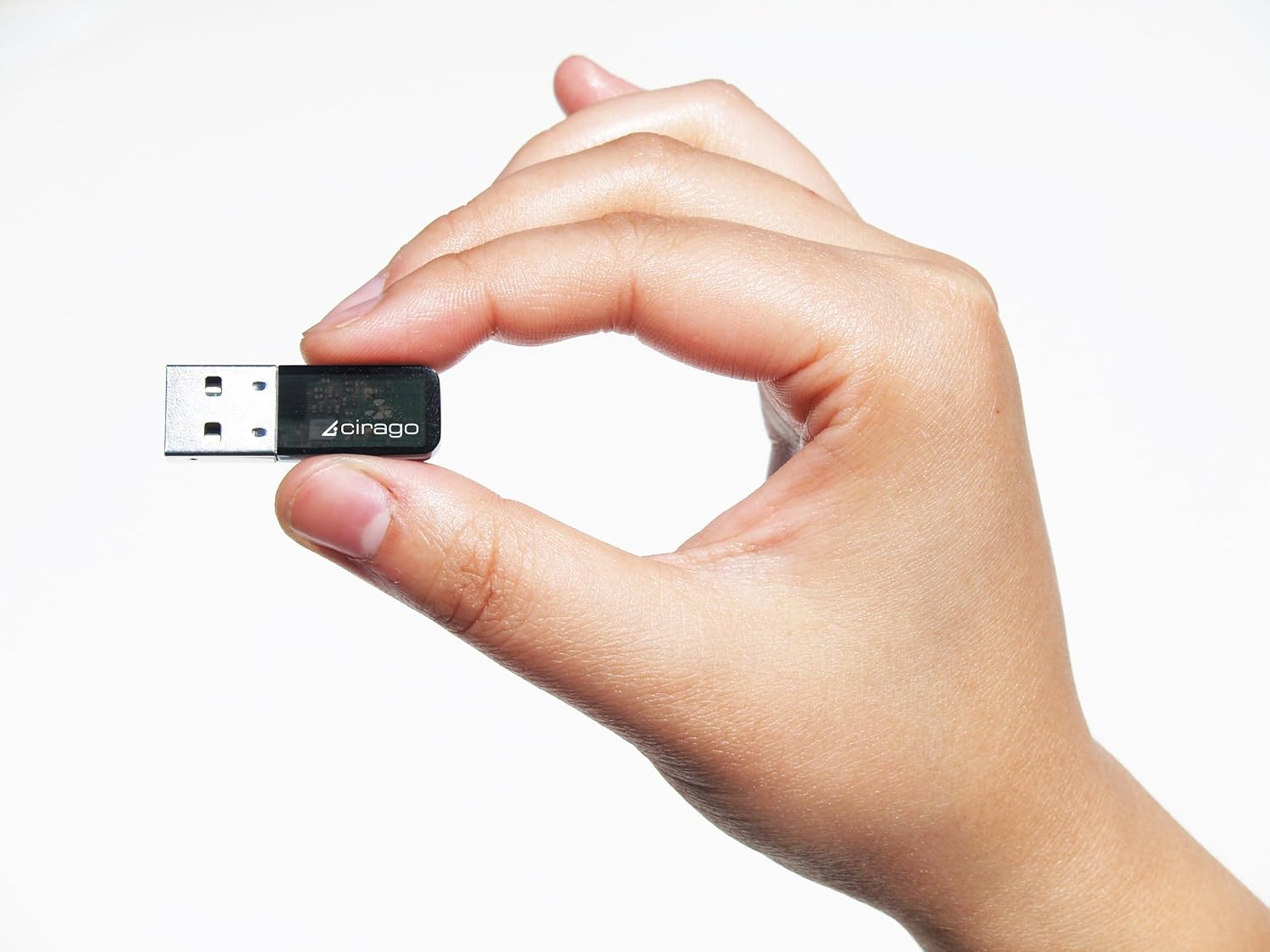 A hand holding the Cirago BTA7300 USB Mini Adapter, highlighting its small form factor.