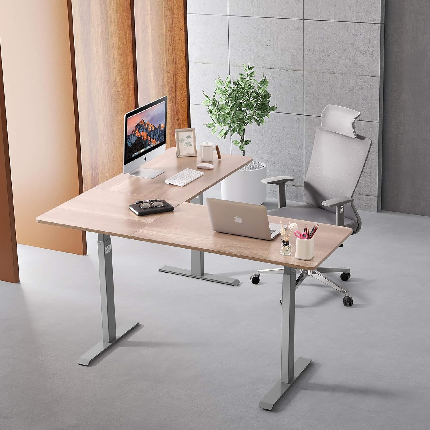 UNICOO L-Shaped Standing Desk set up in an office environment with a computer and laptop.